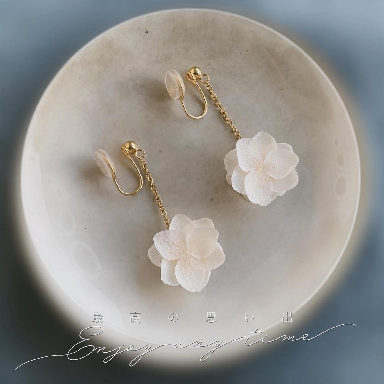 Boucles d'oreilles à clips pour oreille non percée, avec pétales d'hortensias stabilisés blancs, un bijou mariage élégant.