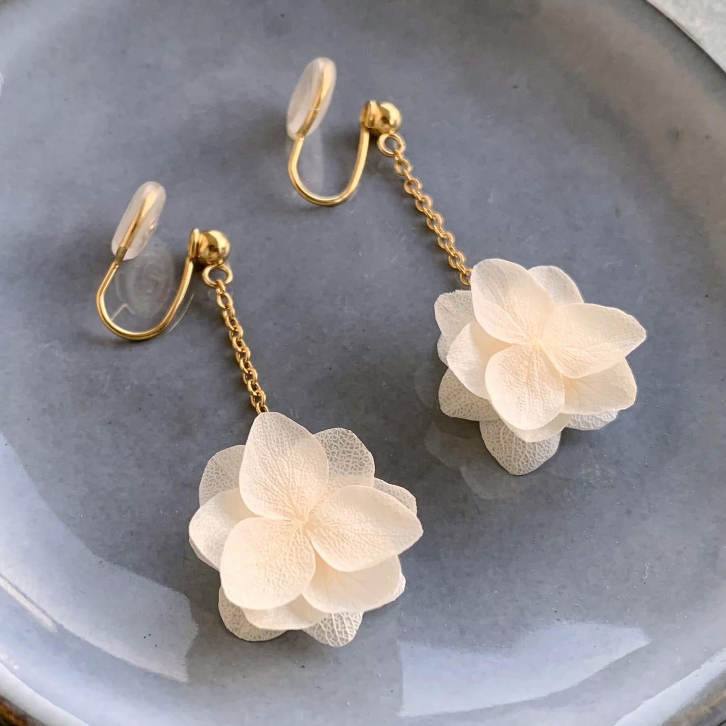 Bijoux faits main par Hana&Alice, ces clips d'oreilles en fleurs d'hortensias stabilisés sont parfaits pour les mariées.