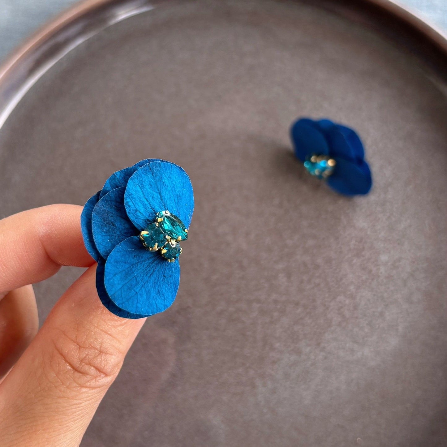 Bijoux floraux hic et raffiné, ces boucles d'oreilles mariage en hortensias bleu saphir / bleu vert et strass signées Hana&Alice apportent une note glamour aux mariées ou invitées lors d'une soirée.