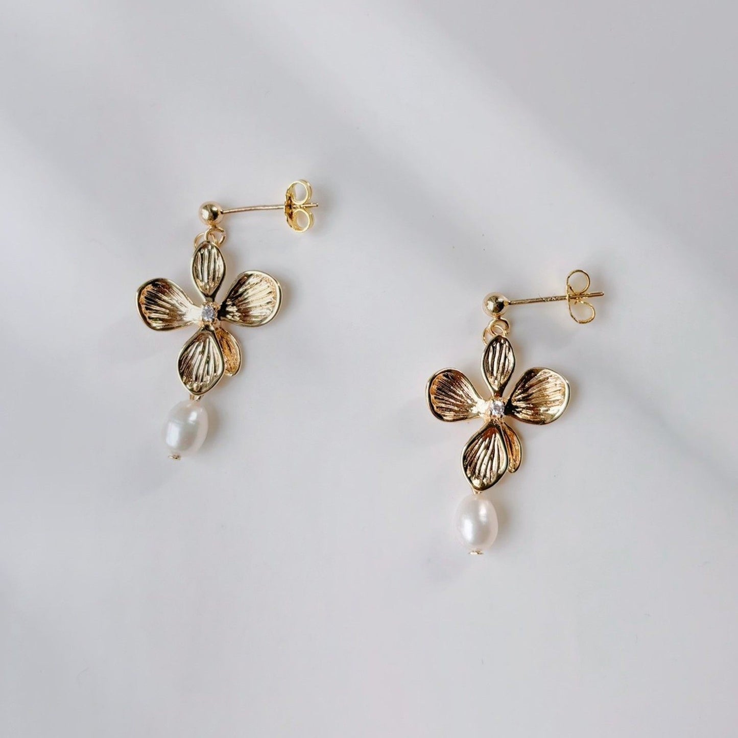 Boucles d’oreilles fleuries en doré, symbole de féminité et de raffinement.