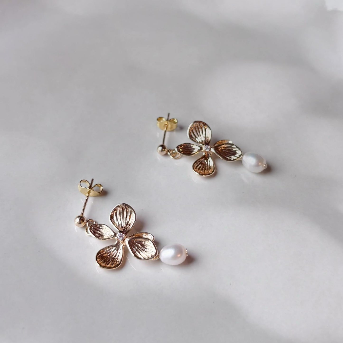 Boucles d’oreilles artisanales dorées et poétiques, inspirées de la nature et de la douceur des perles.
