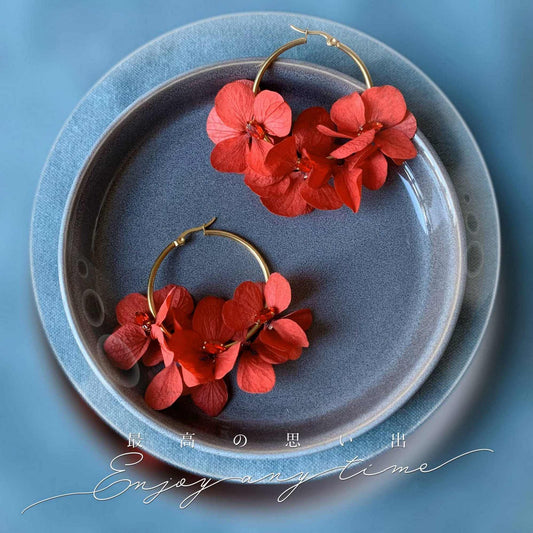 Boucles d'oreilles créoles dorées avec hortensias stabilisés rouges, un bijou fait main idéal pour un mariage ou une soirée élégante.