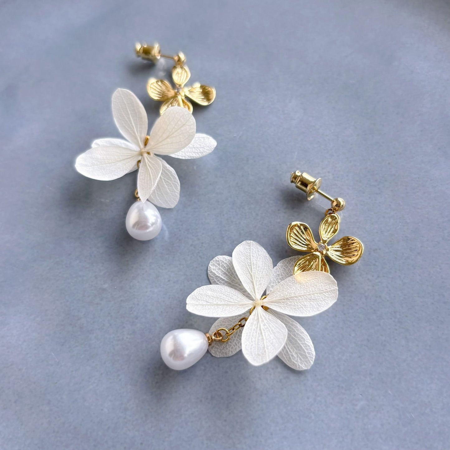 Boucles d’oreilles mariage élégantes avec fleurs d’hortensias stabilisés et perles suspendues.