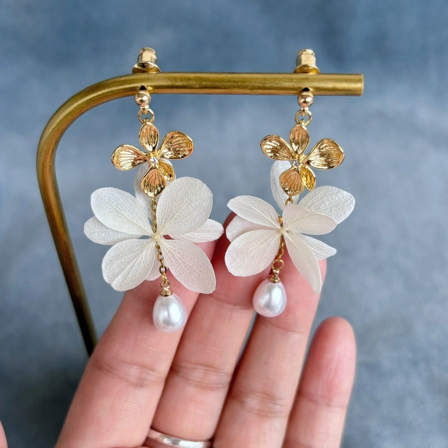 Boucles d’oreilles mariage romantiques avec fleurs stabilisées blanches et perles pendantes.