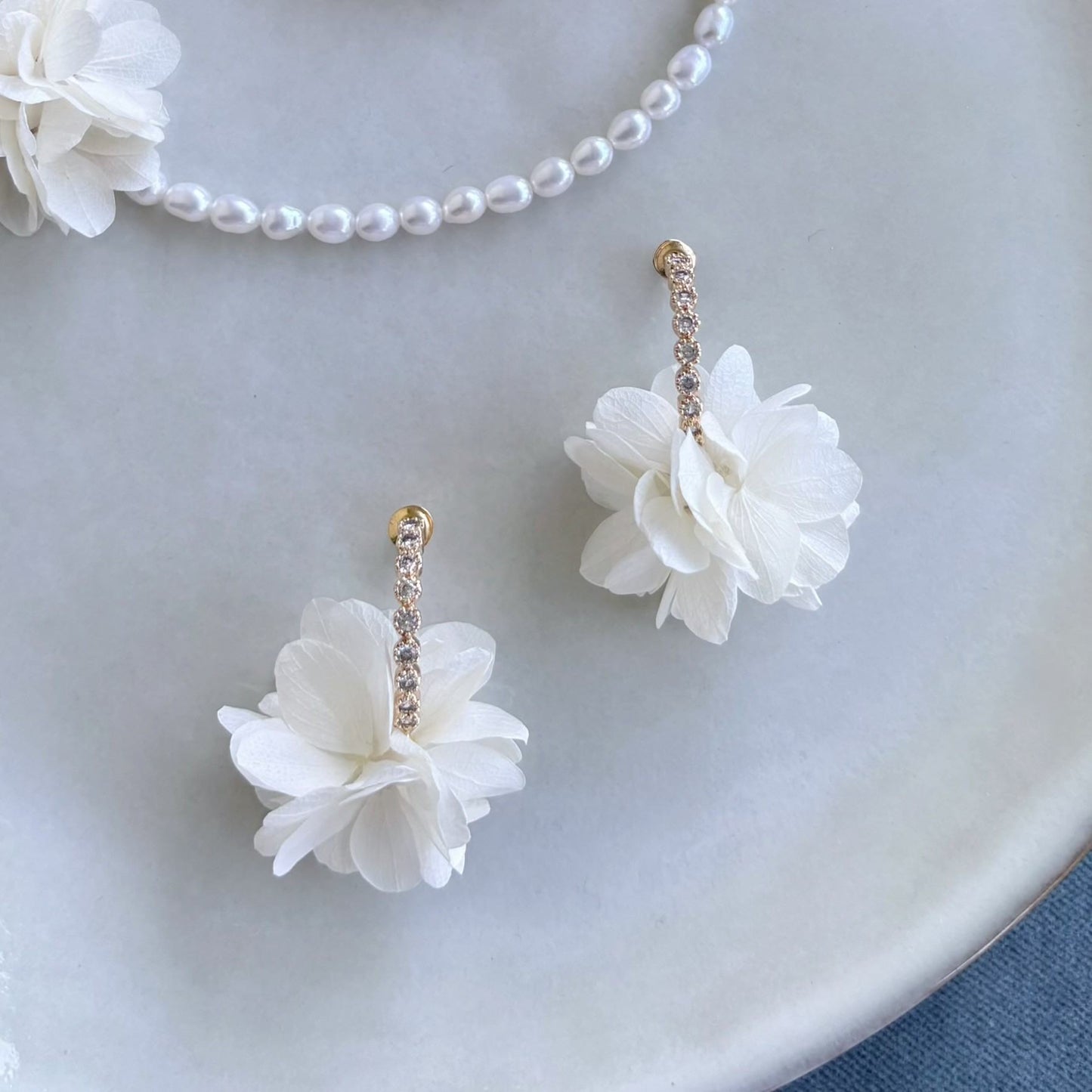Boucles florales raffinées pour mariage, composées d’hortensias délicats et de crochets dorés ornés de cristaux