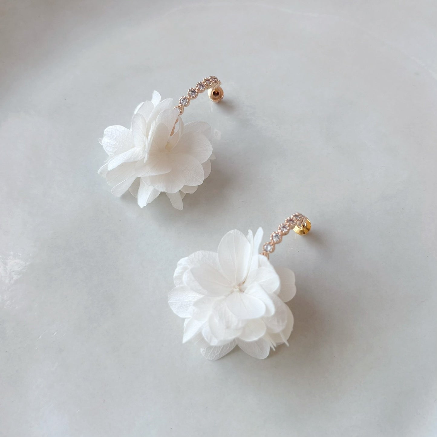 Accessoire raffiné pour événement spécial, avec fleurs d’hortensias et cristaux sur crochets dorés élégants