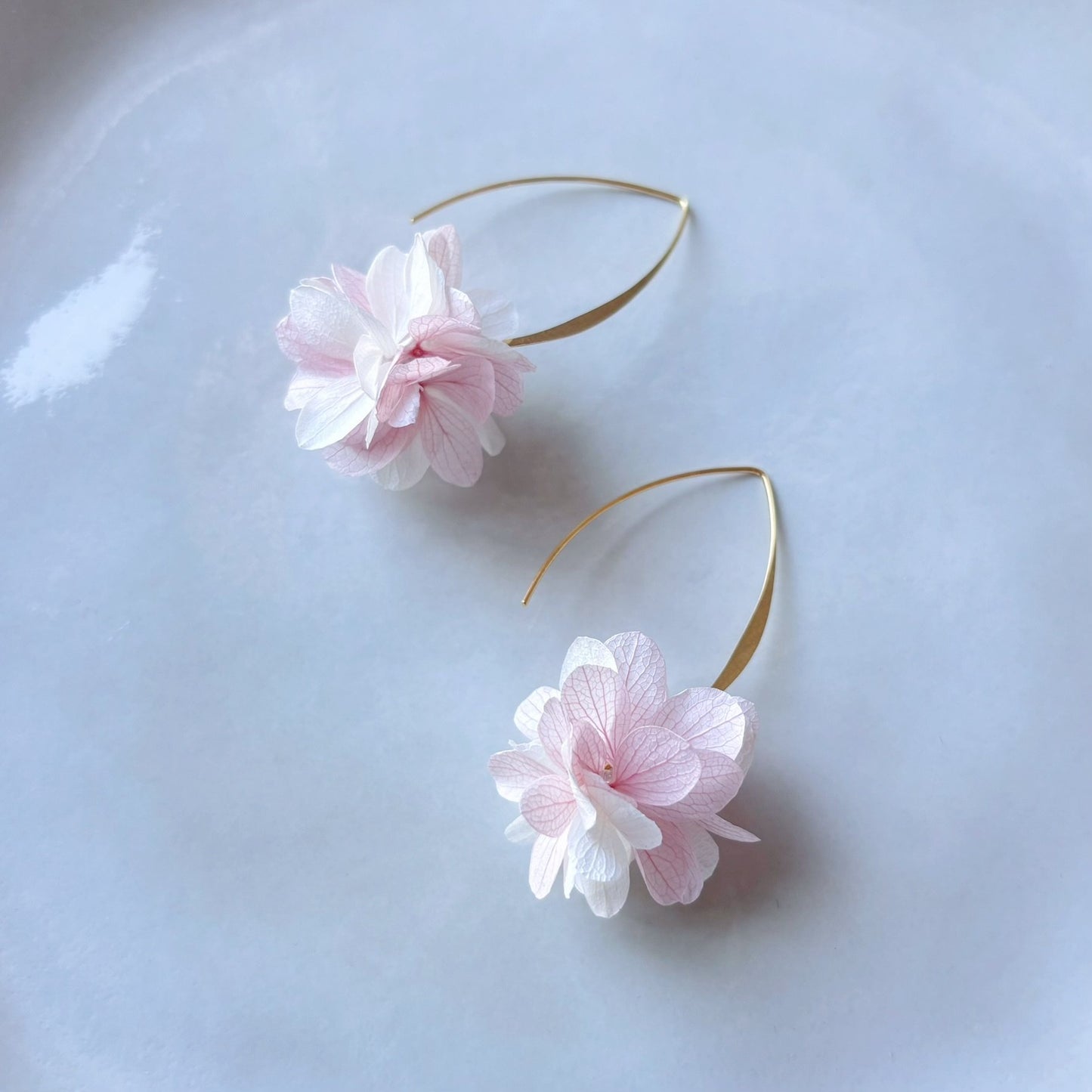 Boucles d’oreilles mariage en crochet V, fleurs stabilisées blanc et rose clair.