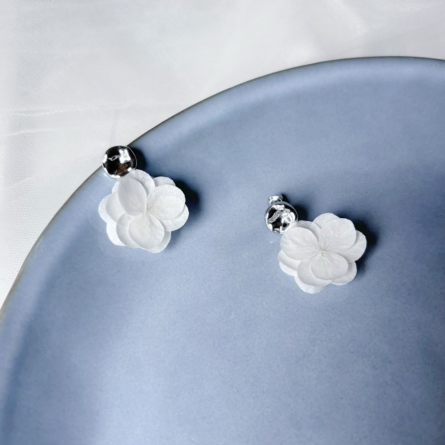 Parure de bijoux pour mariée, en fleurs stabilisées blanches.