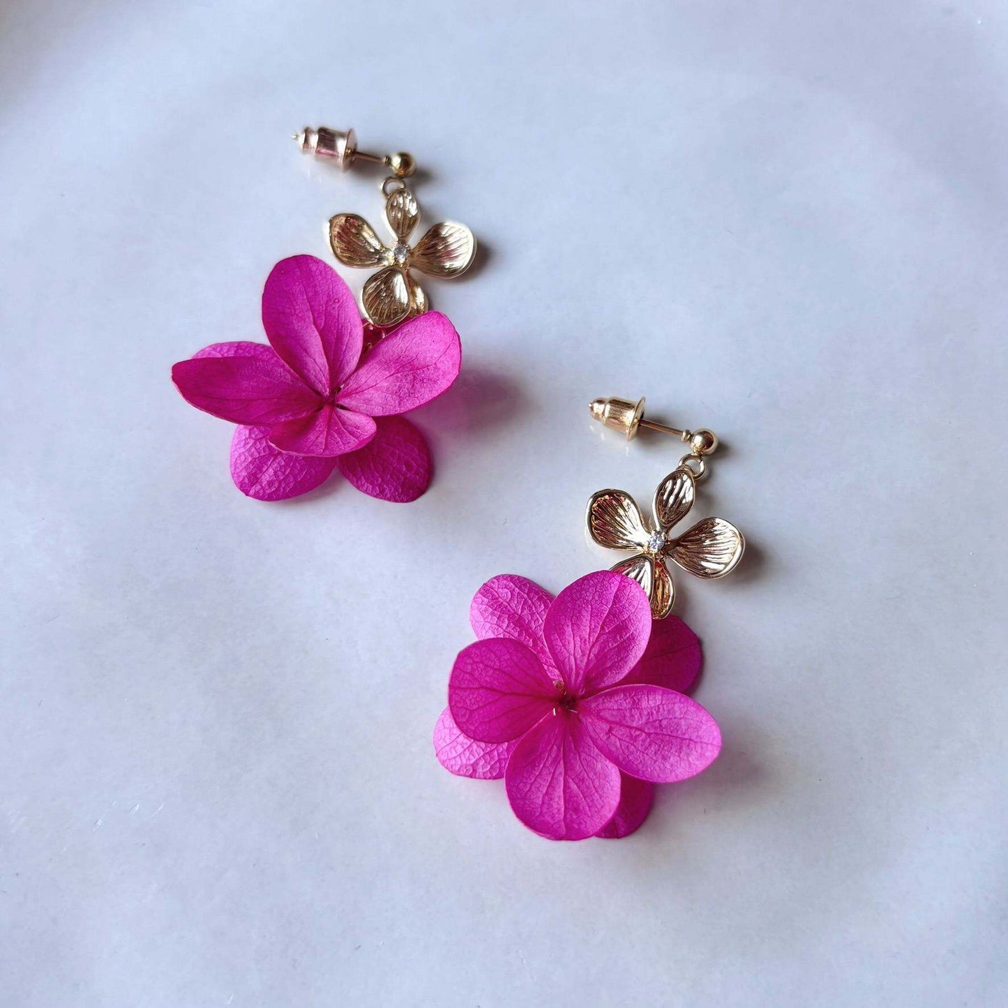 Boucles d’oreilles mariage en fleurs naturelles stabilisées rose fuchsia, création artisanale délicate.