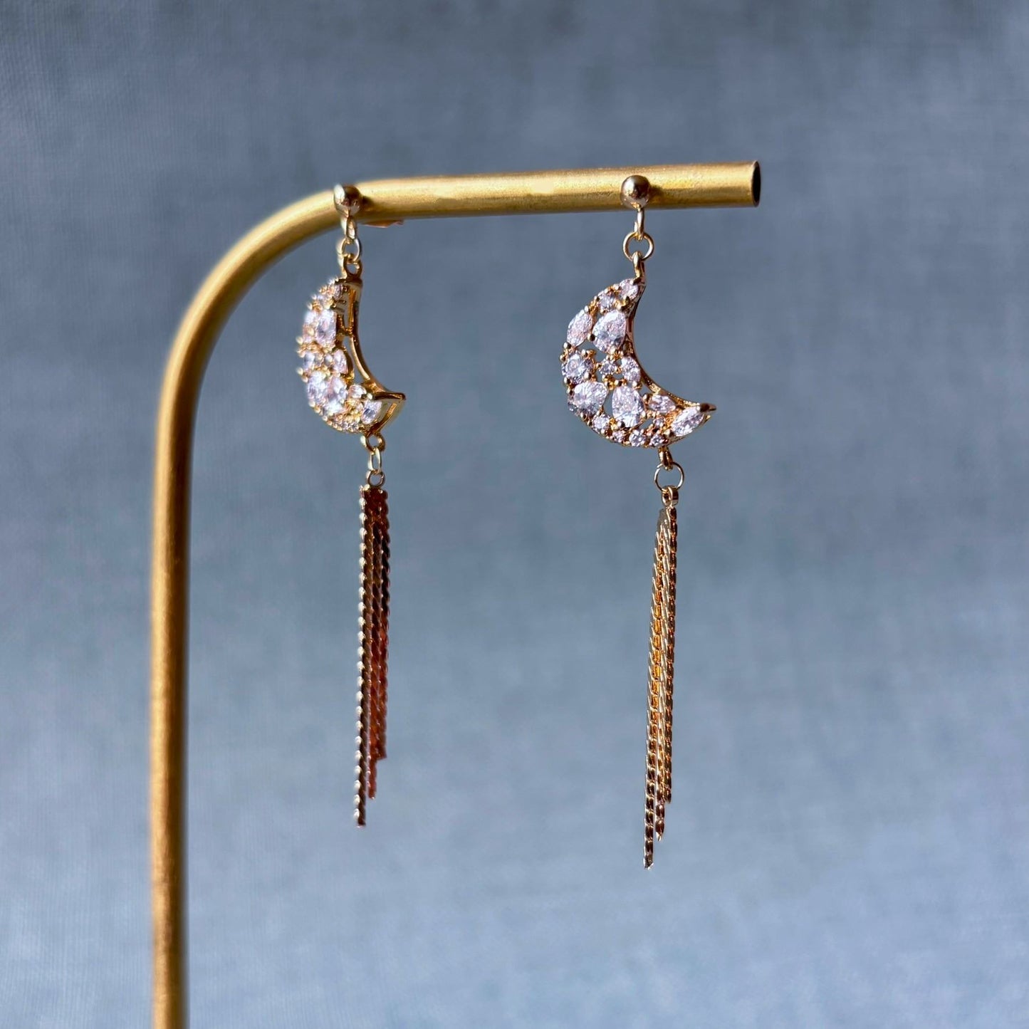 Bijoux poétiques faits main, croissant de lune argenté et chaînes fines lumineuses.