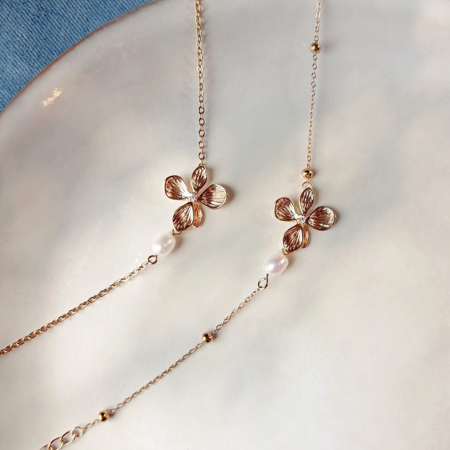 Bracelet fleuri doré et perle naturelle, à associer aux boucles d’oreilles Sofia Pearl.