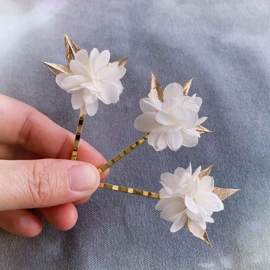 Épingles à cheveux florales pour mariage, ornées de fleur d’hortensia stabilisée blanche et ruscus doré.