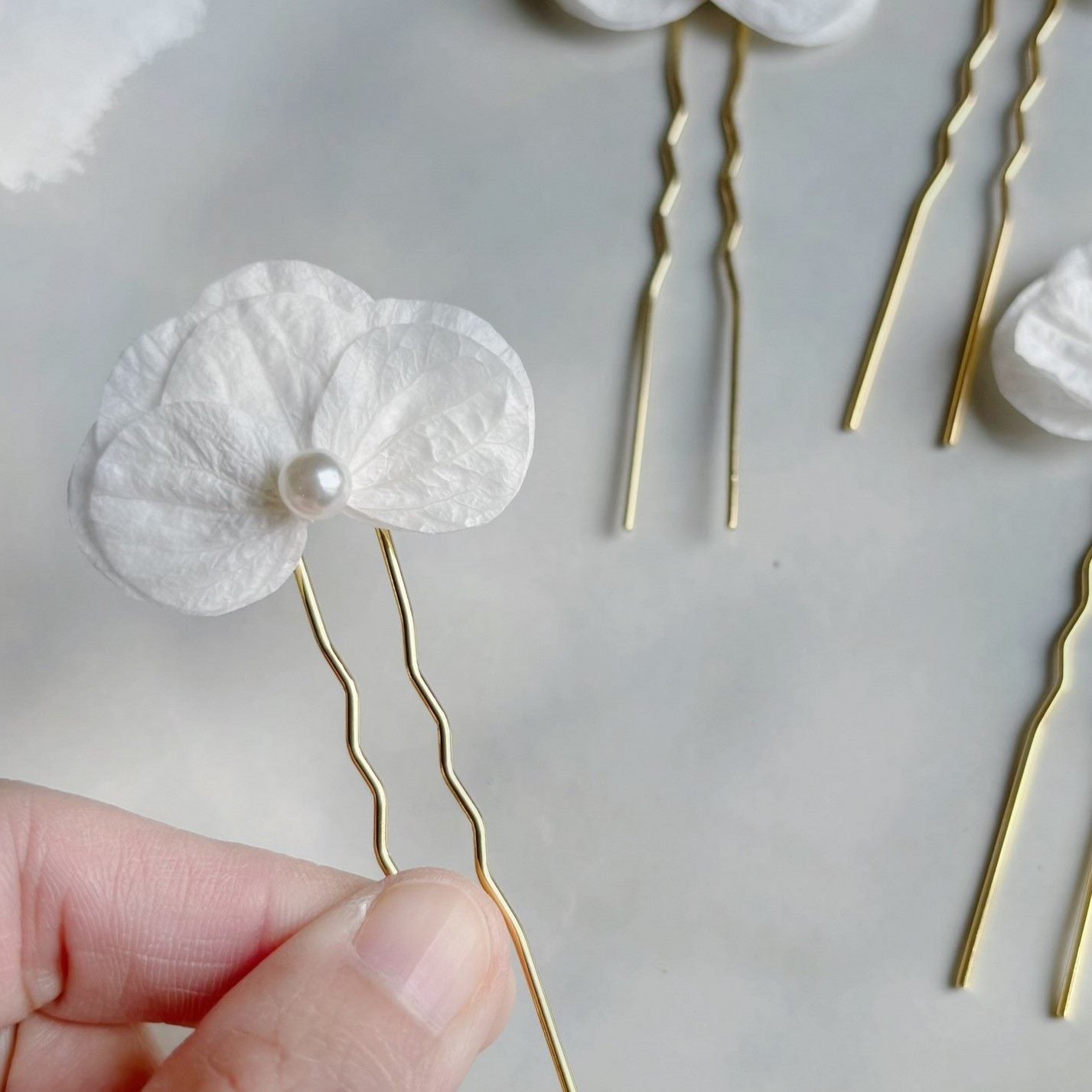 Épingles à cheveux artisanales pour coiffure de mariée, avec des détails floraux uniques.