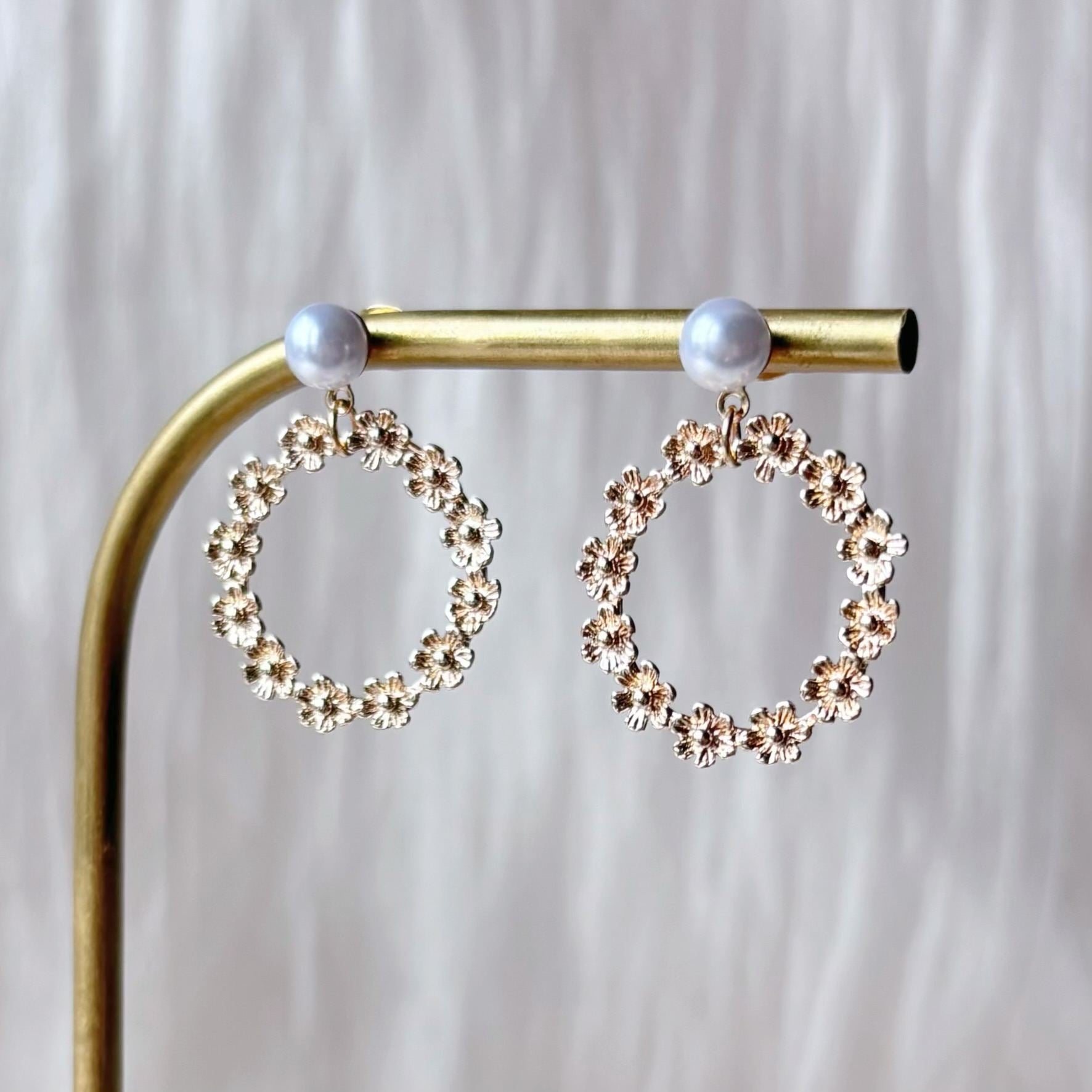 Bijoux mariage fleur délicats avec créole dorée et perle, parfaits pour les mariées et invitées.