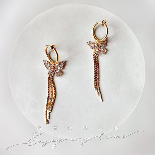 Boucles d’oreilles à clips en acier inoxydable, papillon brillant et chaîne délicate.