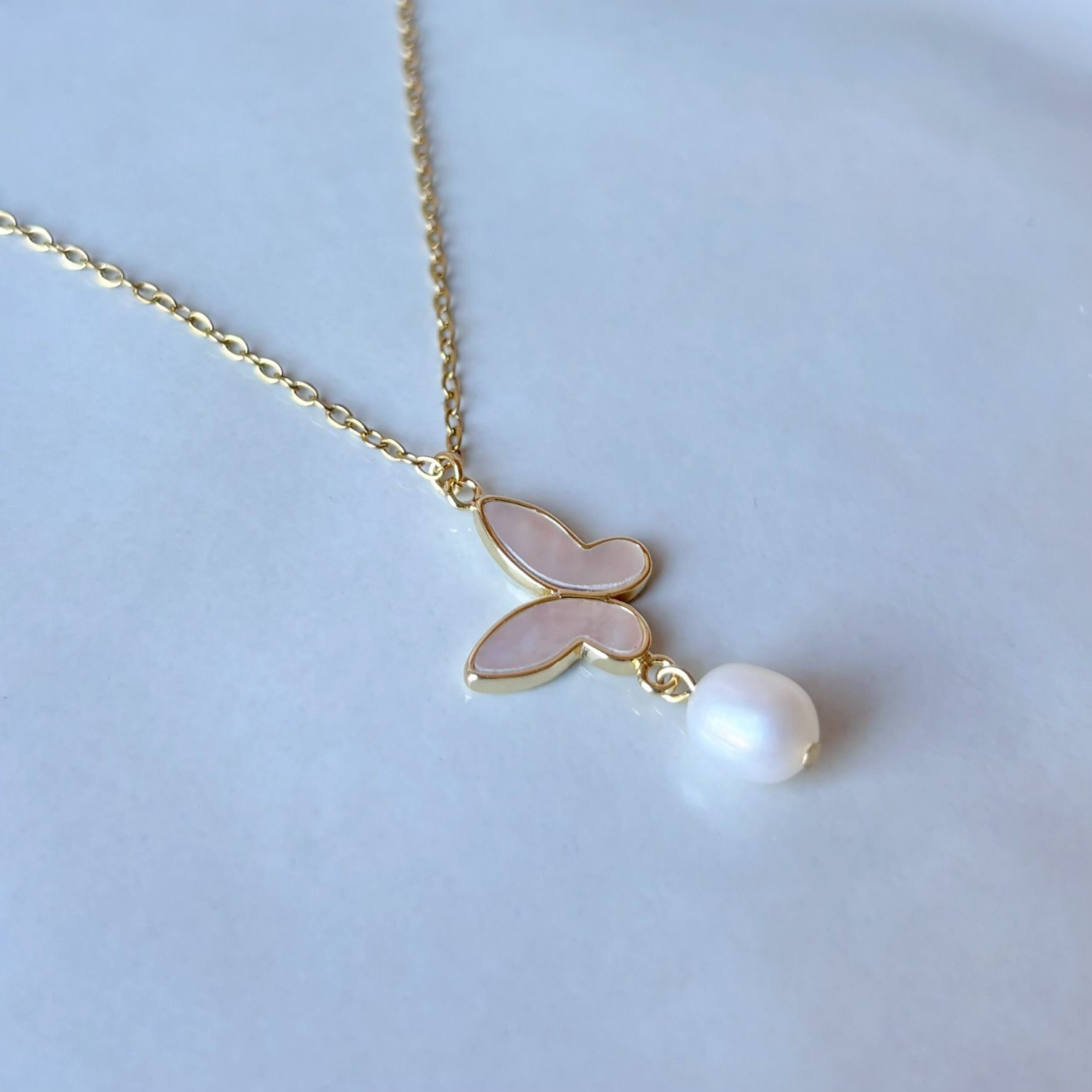 Collier femme avec papillon nacré et perle naturelle, accessoire délicat pour une occasion spéciale