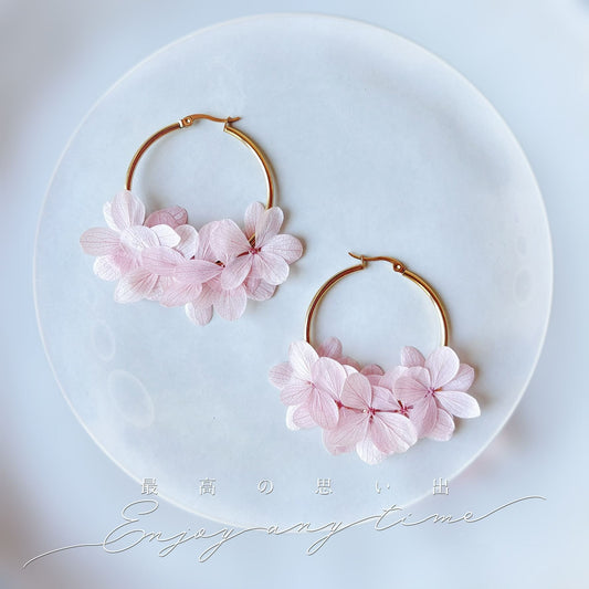 Bijoux mariage créoles en hortensias stabilisés rose clair, une touche florale pour la mariée.