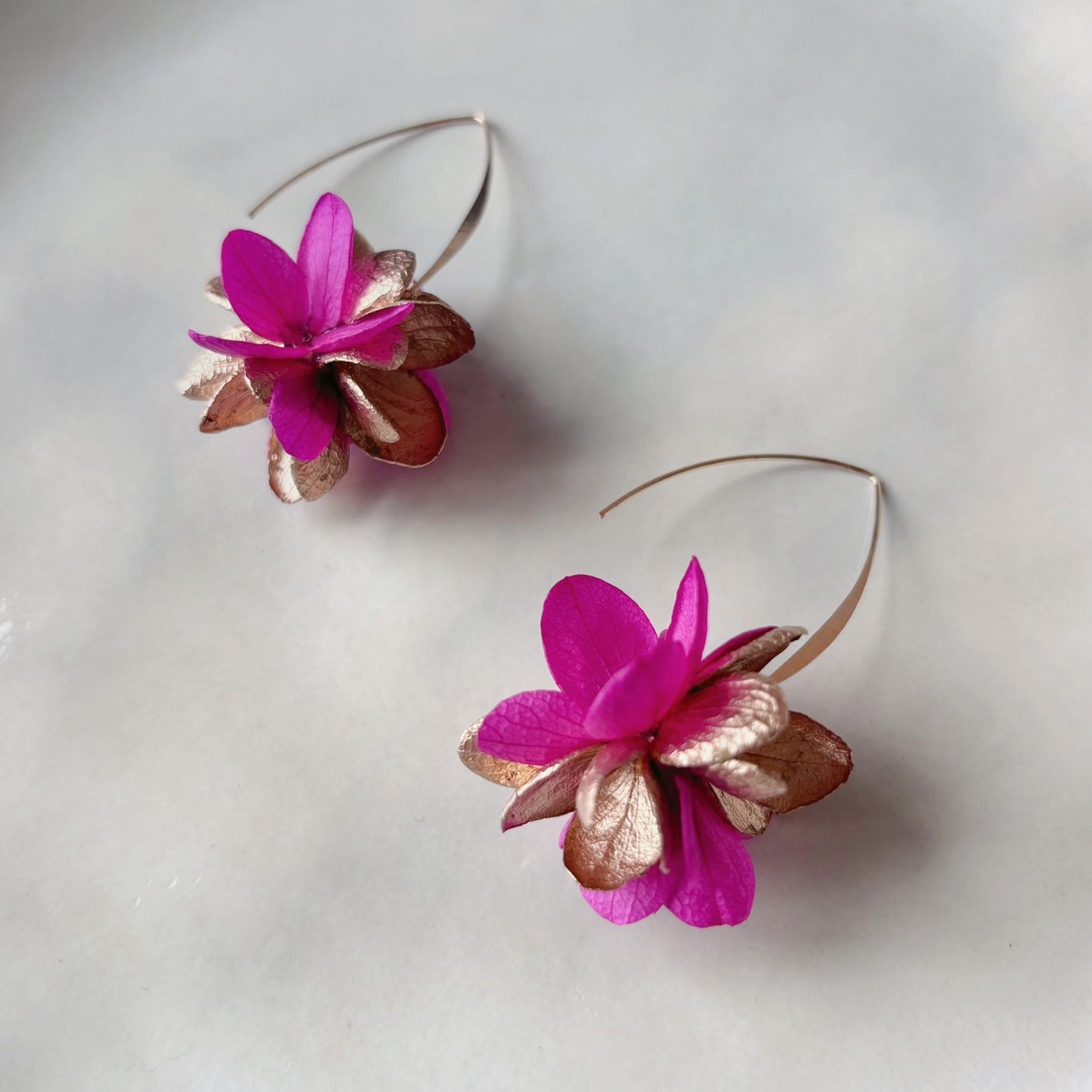 Boucles d’oreilles mariage artisanales, fleurs naturelles fuchsia et dorées, création poétique et raffinée pour cérémonie.