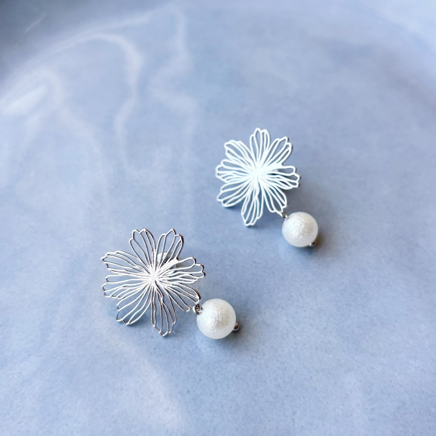 Détail du collier mariage avec pendentif fleur dorée délicate et perle lumineuse suspendue