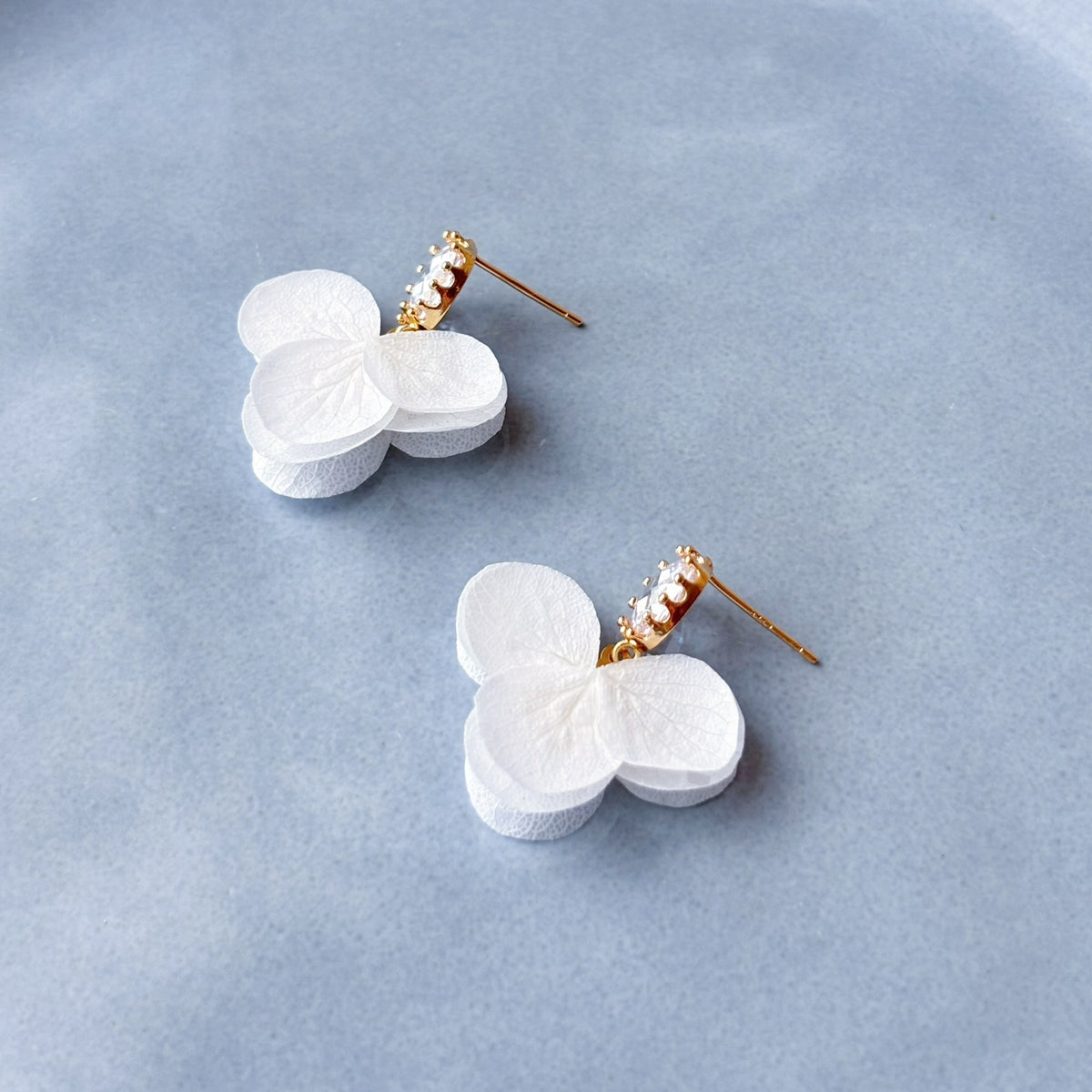 Accessoire de mariée raffiné avec petites fleurs blanches stabilisées et cristaux ovales scintillants