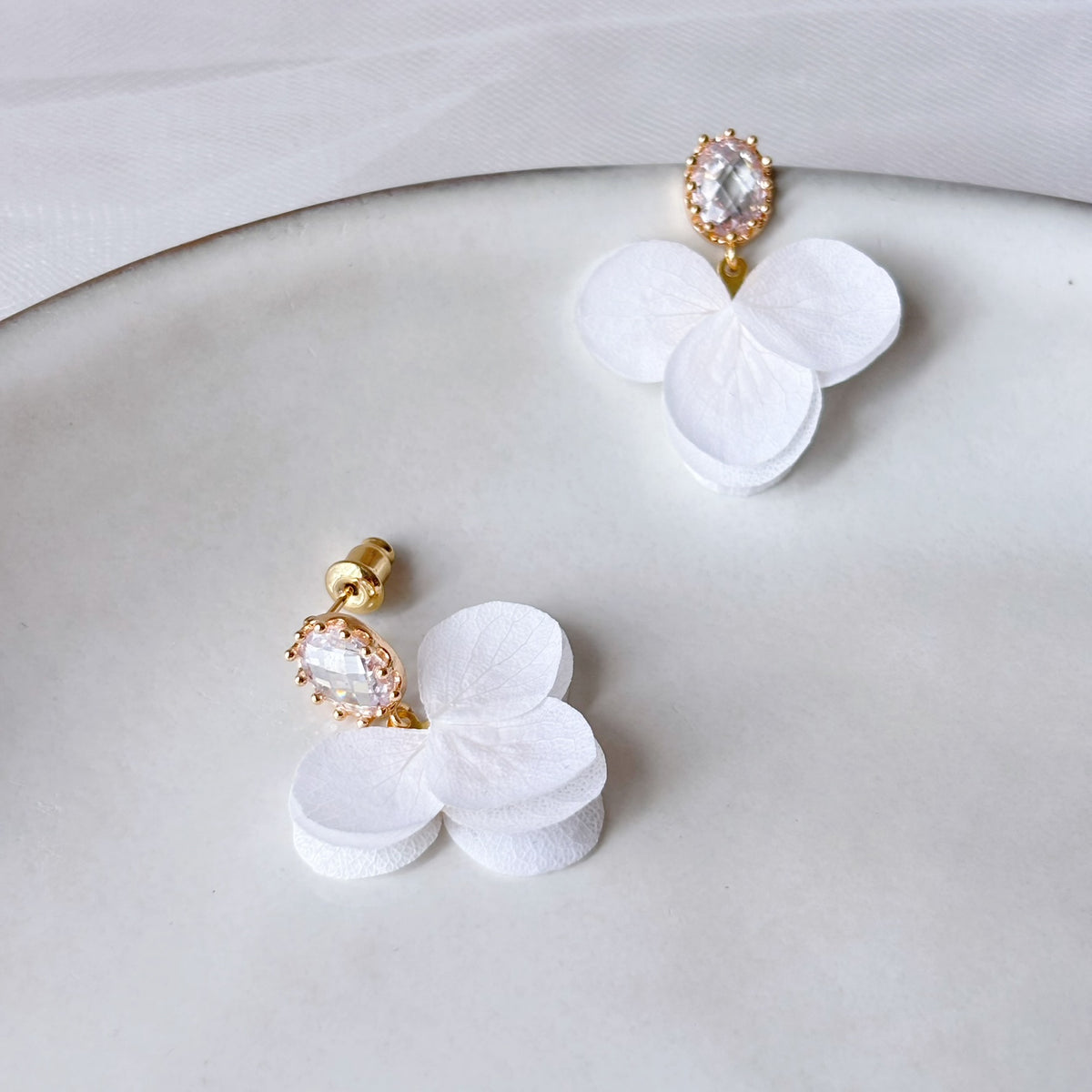 Boucles d’oreilles florales chic avec clous ovales en cristal et petites fleurs blanches suspendues