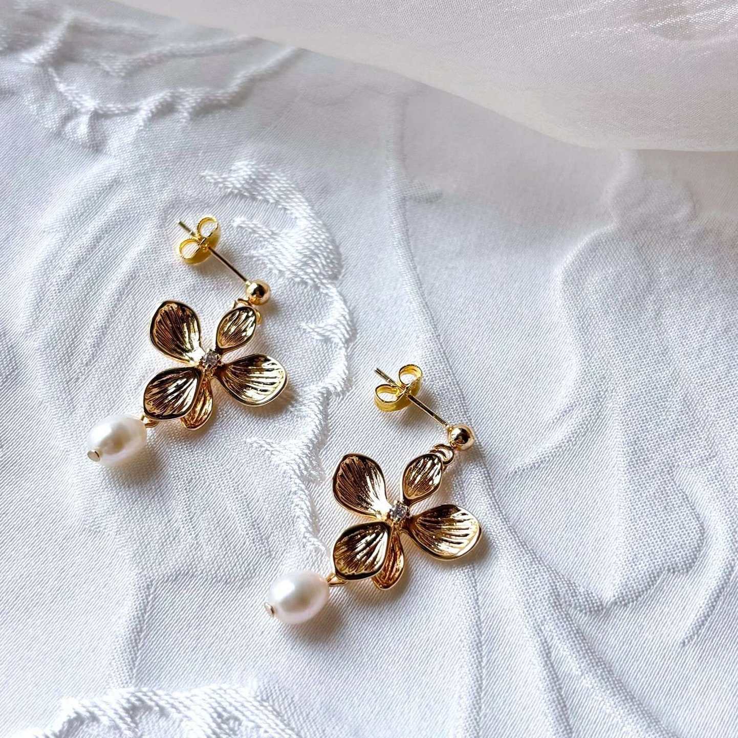 Boucles d’oreilles fleuries en doré, symbole de féminité et de raffinement.