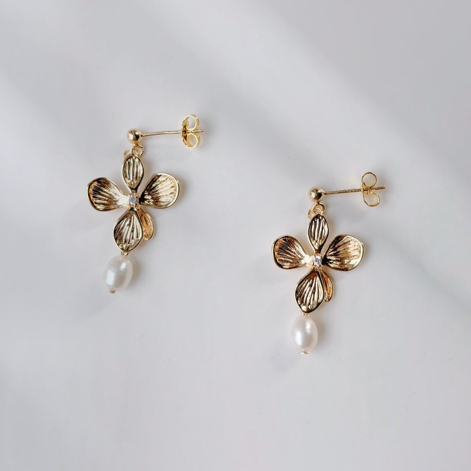Boucles d’oreilles fleuries en doré, symbole de féminité et de raffinement.