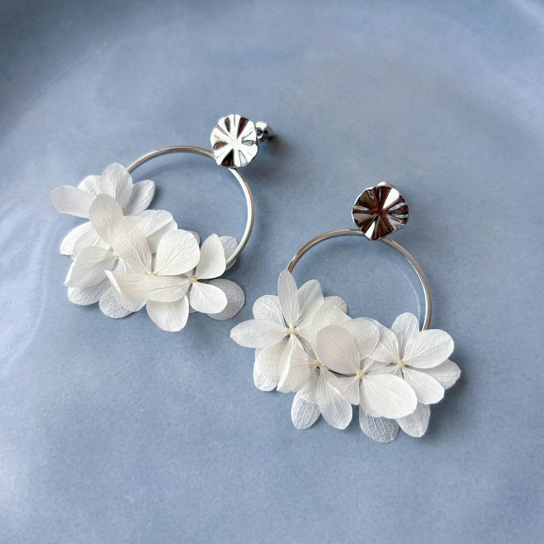 Boucles d’oreilles créoles pour mariée en fleurs d'hortensias stabilisées blanches et créoles dorées ou argentées. Accessoire élégant et poétique pour mariée signés Hana&Alice