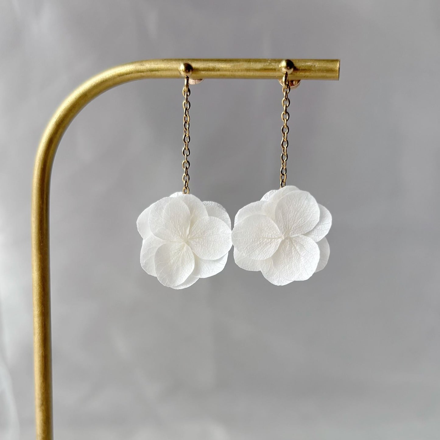 Accessoire raffiné : boucles pendantes en fleurs stabilisées, idéales pour un mariage coloré.