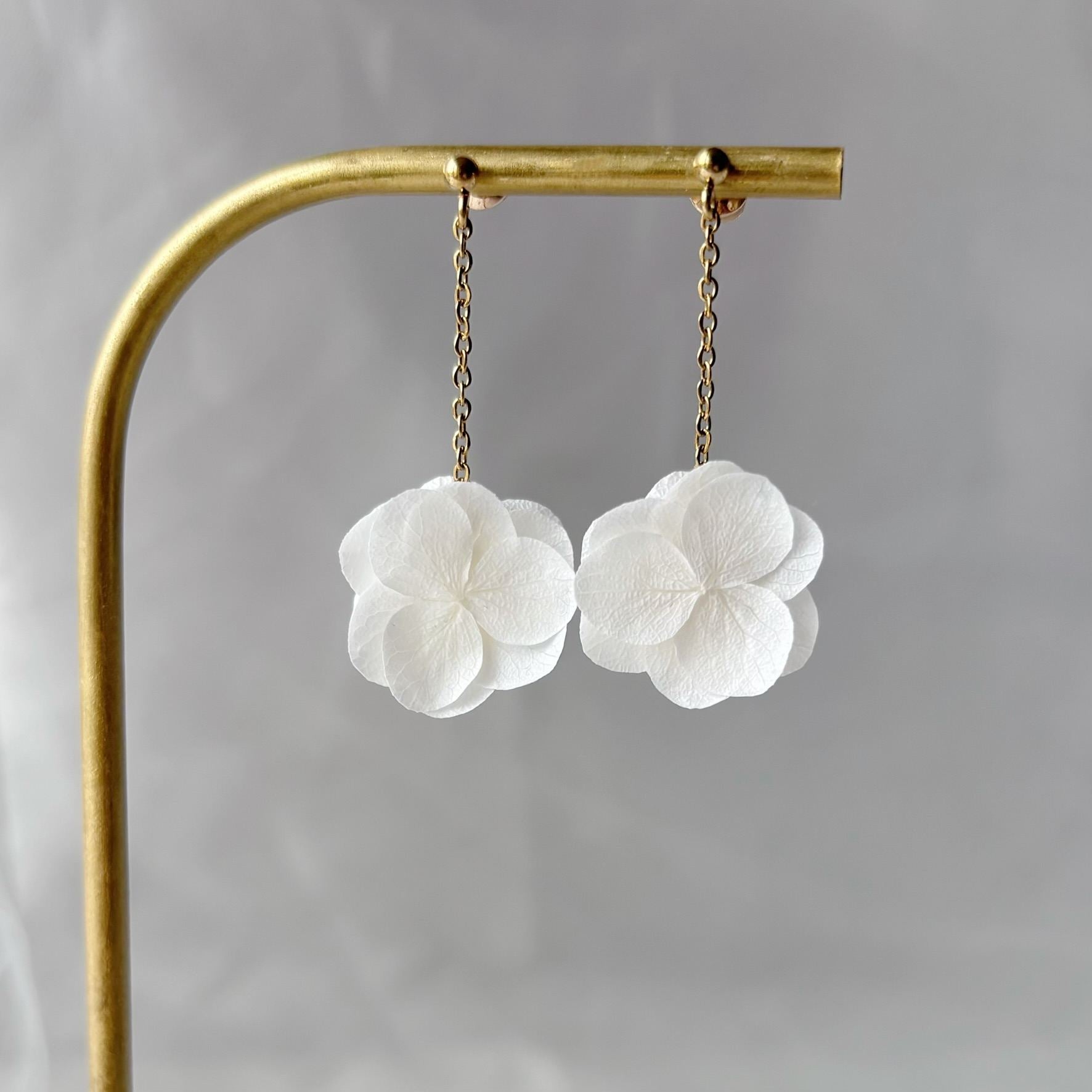 Accessoire raffiné : boucles pendantes en fleurs stabilisées, idéales pour un mariage coloré.