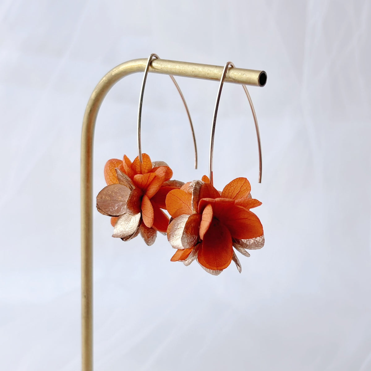 Boucles d’oreilles mariage originales Hana&Alice, en fleurs stabilisées terracotta et dorée, idéales pour mariage bohème chic automnal.