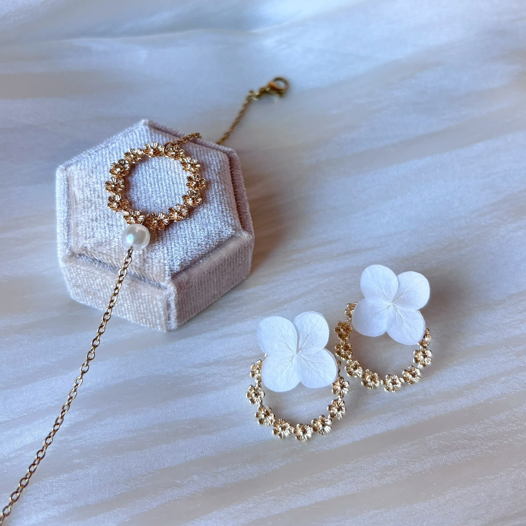 Accessoire mariage unique : boucles d'oreilles florales en pétales d'hortensias et couronne dorée.