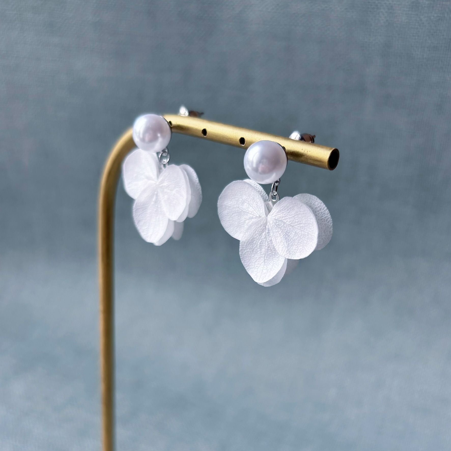 Boucles d'oreilles en perles et hortensias stabilisés blancs, un choix délicat et floral pour sublimer votre tenue de mariage ou d’anniversaire.