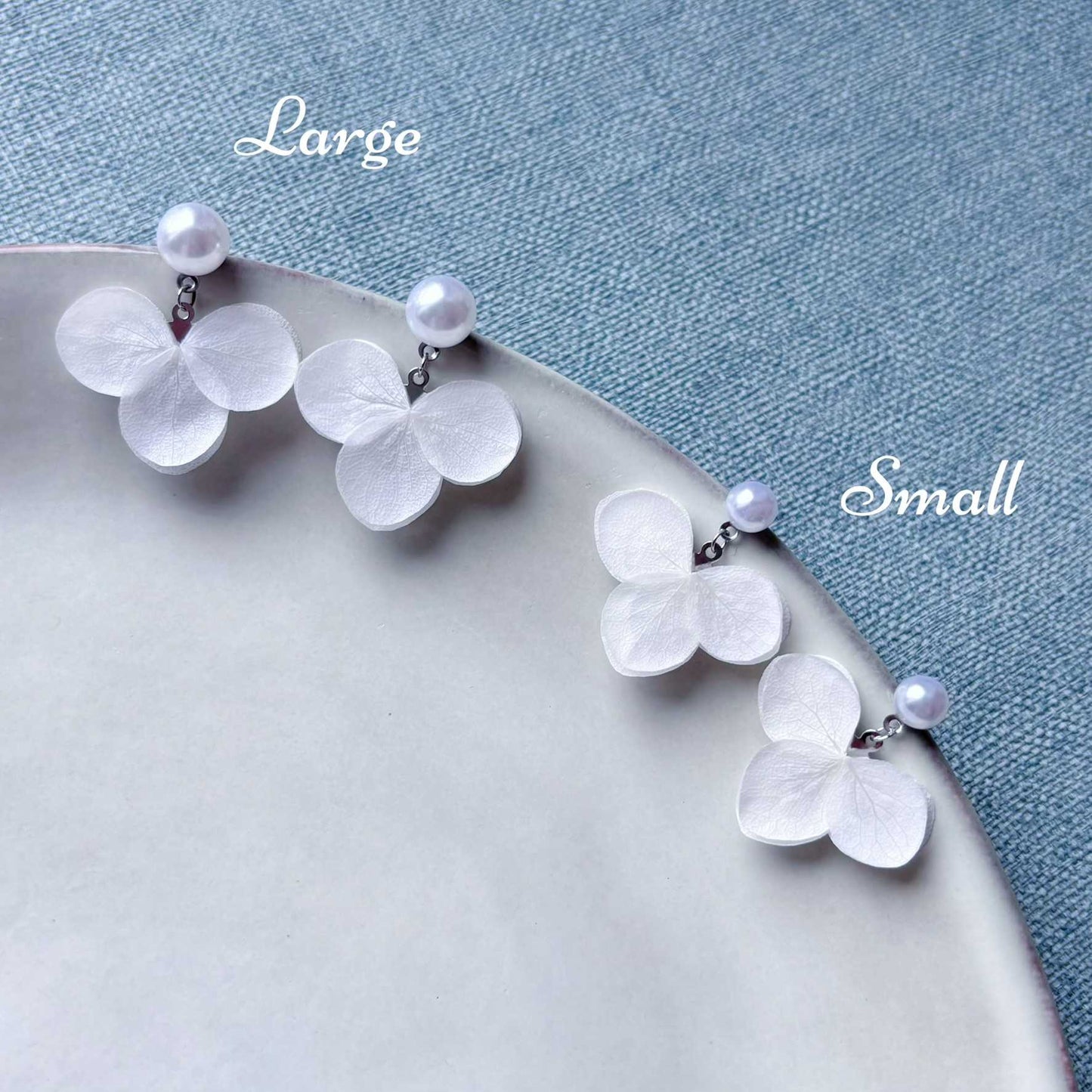 Boucles d'oreilles mariage élégantes en hortensias stabilisés blancs et perles, conçus pour un mariage romantique et chic.