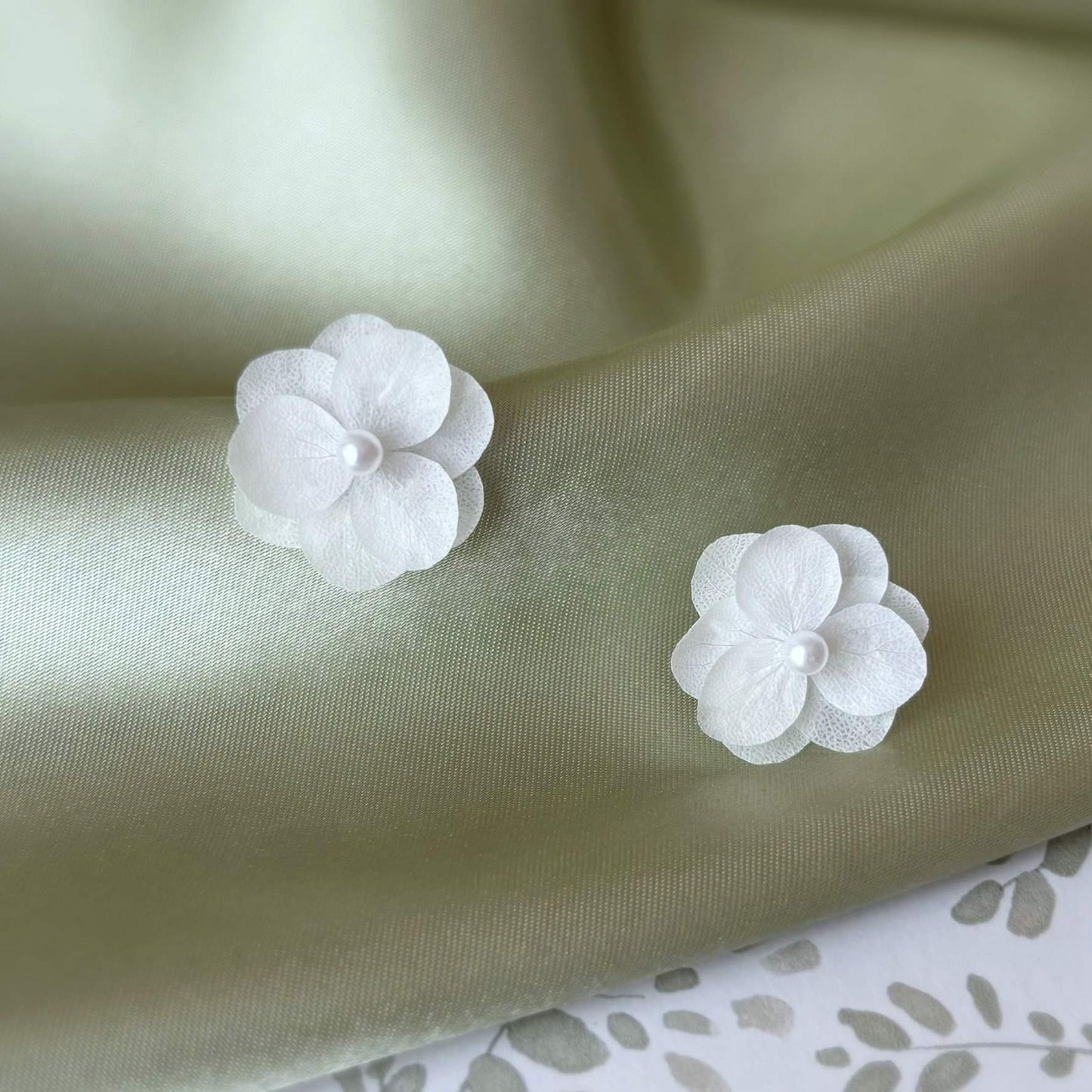 Bijoux mariage avec boucles d'oreilles fleur, parfaits pour un look frais et naturel grâce à l'harmonie des hortensias stabilisés et de la perle.