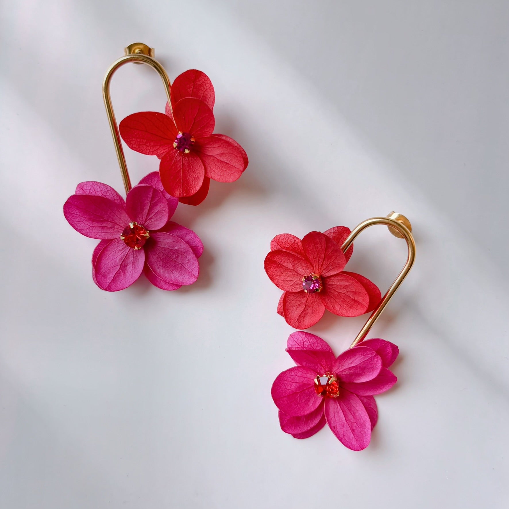 Boucles d’oreilles fleurs stabilisées rouge et rose fuchsia, création artisanale raffinée pour mariée.
