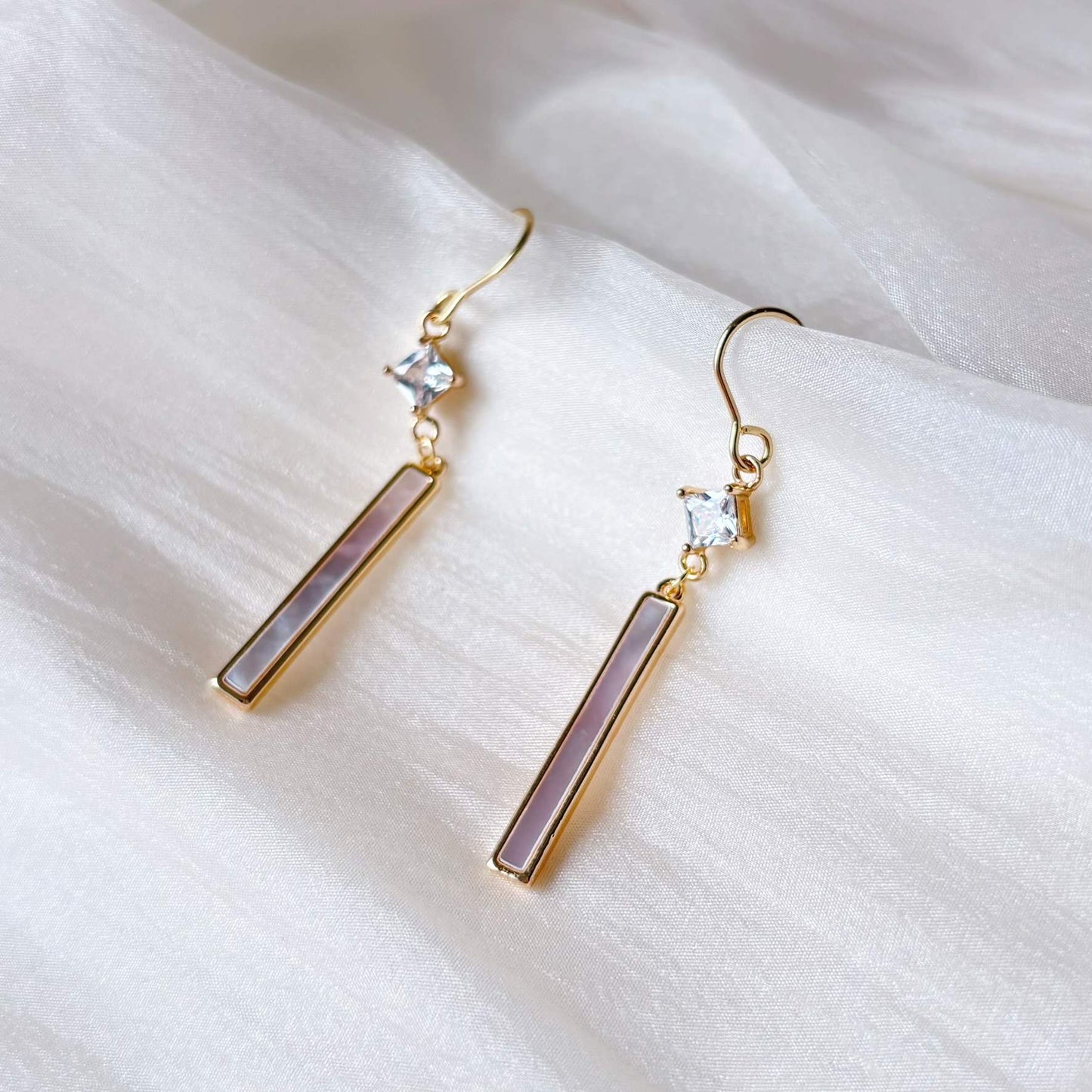 Boucles d’oreilles dorées lumineuses avec cristal carré et barre nacrée