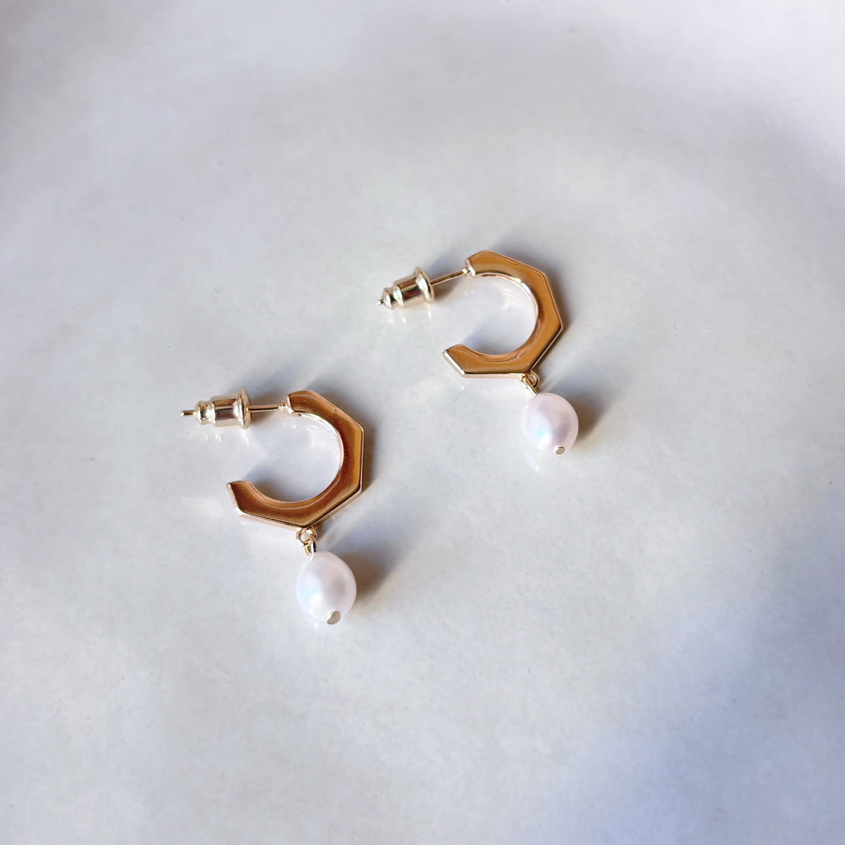 Boucles d’oreilles délicates avec perles blanches suspendues à des créoles dorées