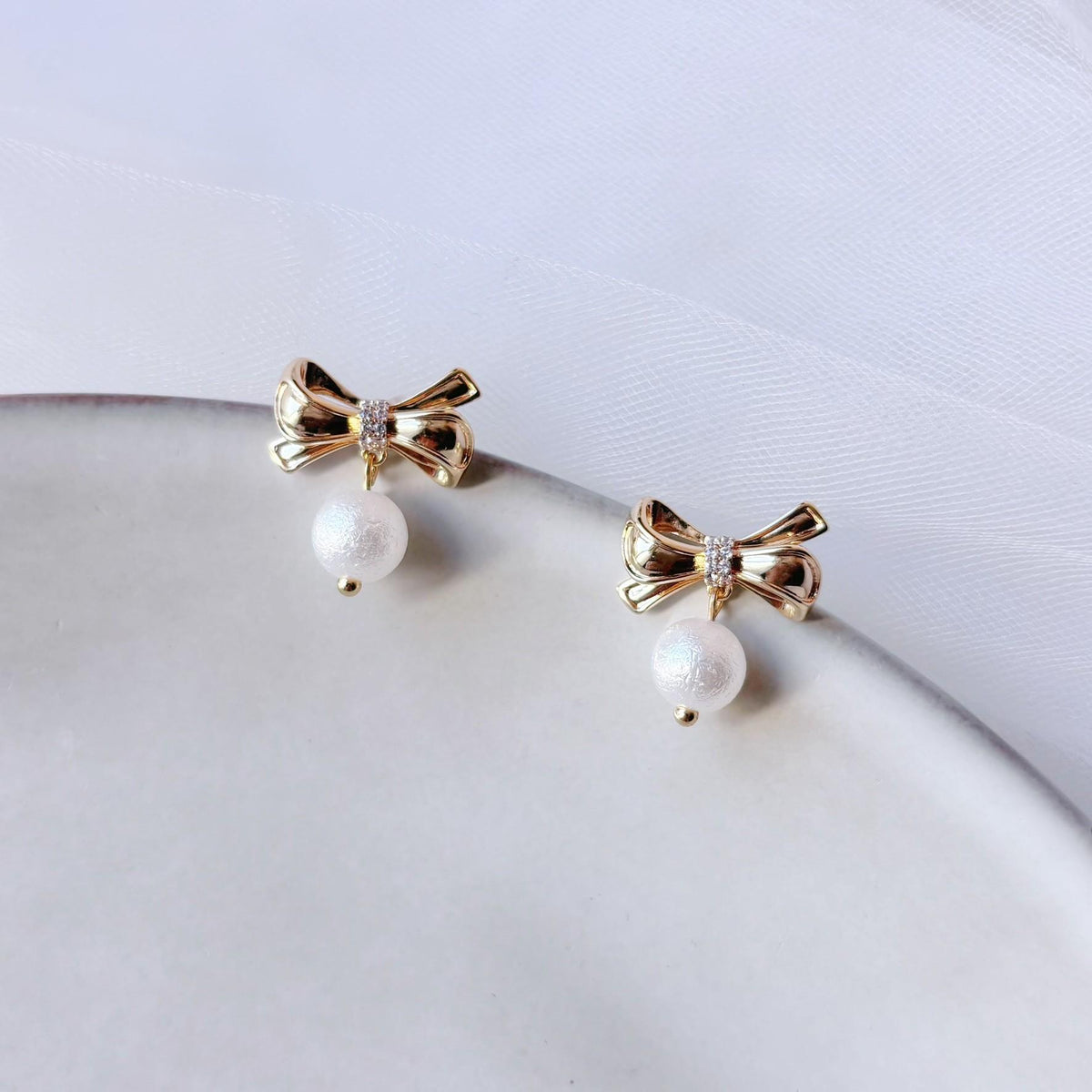 Paire de boucles d’oreilles dorées élégantes avec motif nœud et perle