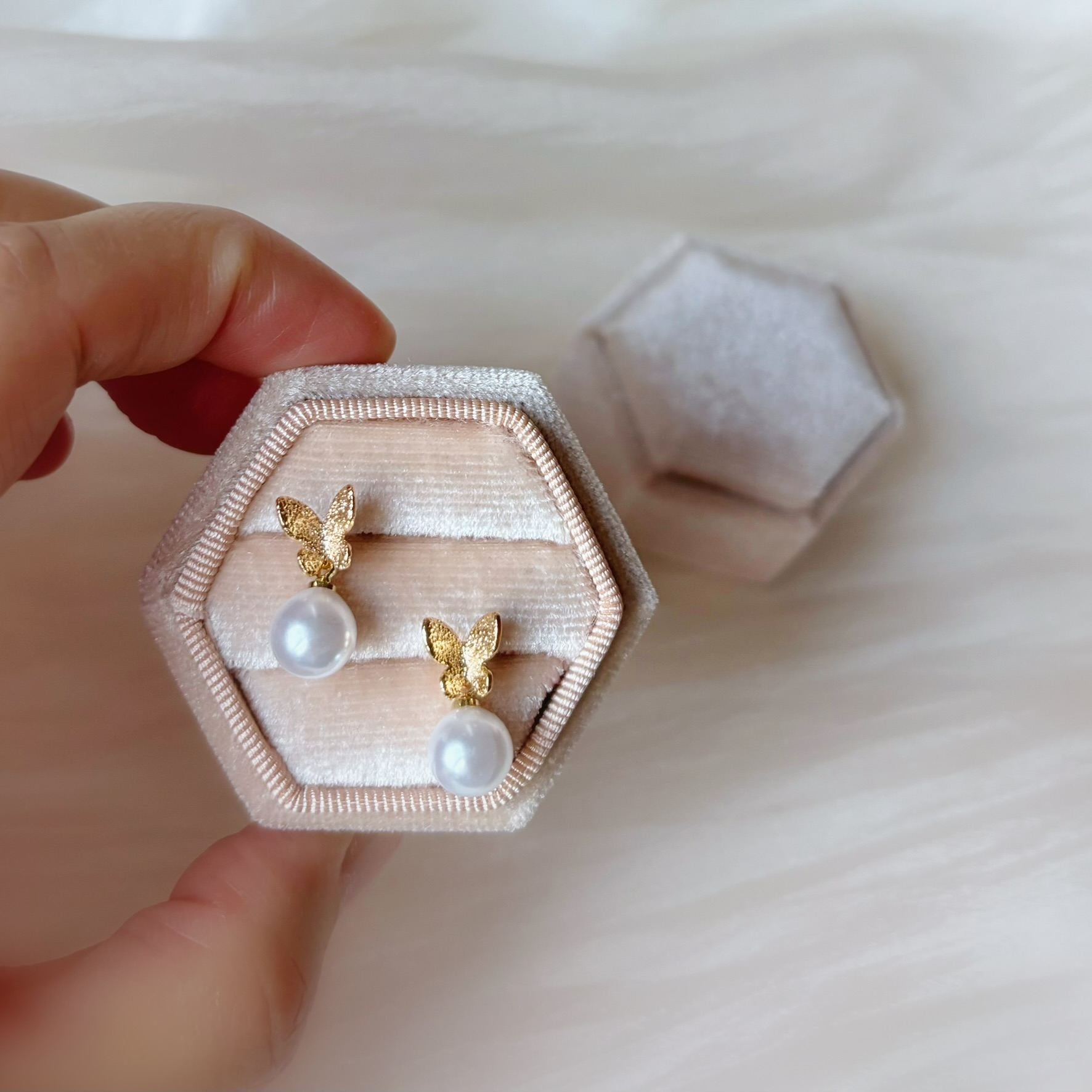 Boucles d'oreilles perle ronde papillon, l'accessoire idéal pour un mariage romantique.