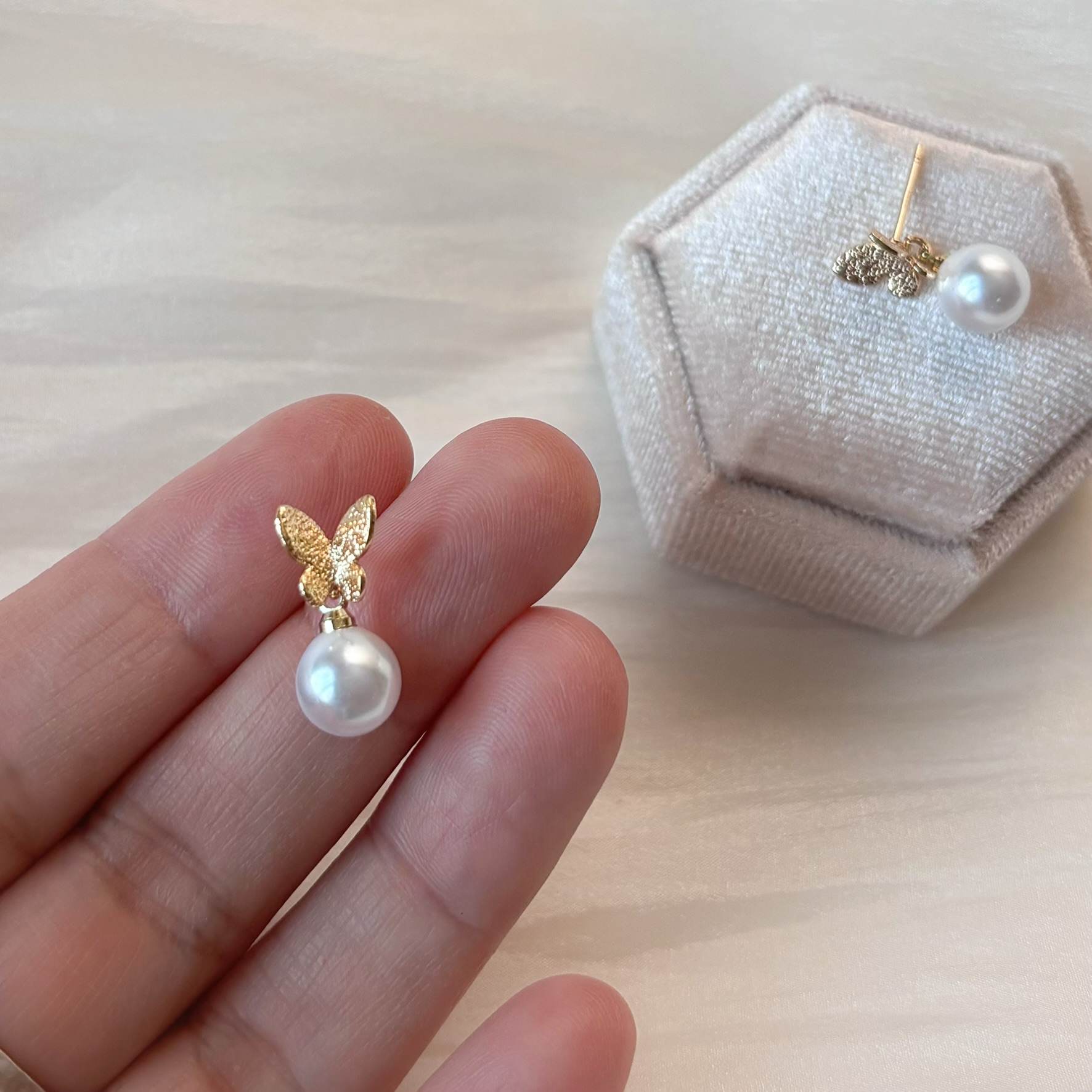 Boucles d'oreilles mariage chic et élégantes, avec perle ronde et design papillon raffiné.