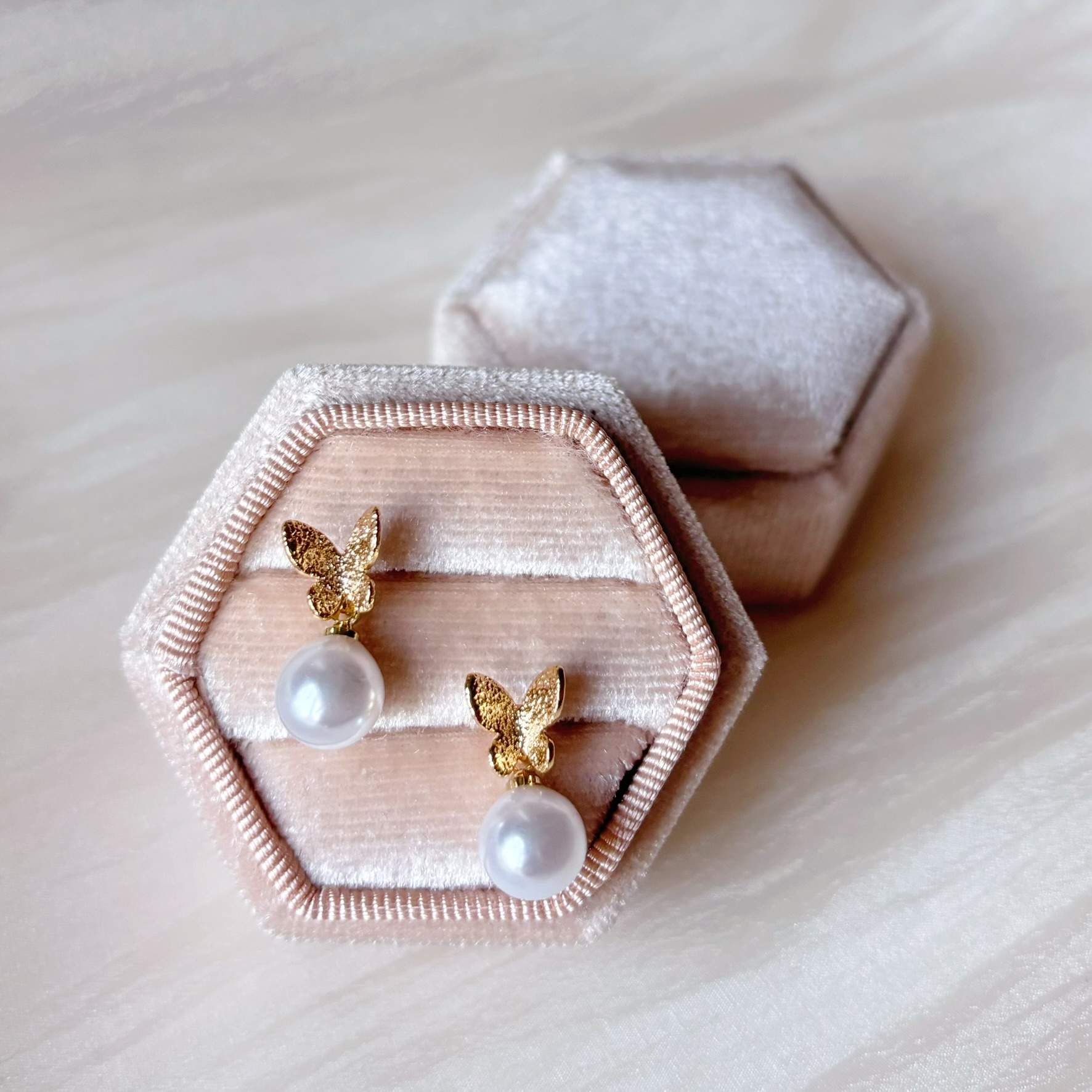 Boucles d'oreilles mariage élégantes, avec perle ronde et design papillon raffiné.