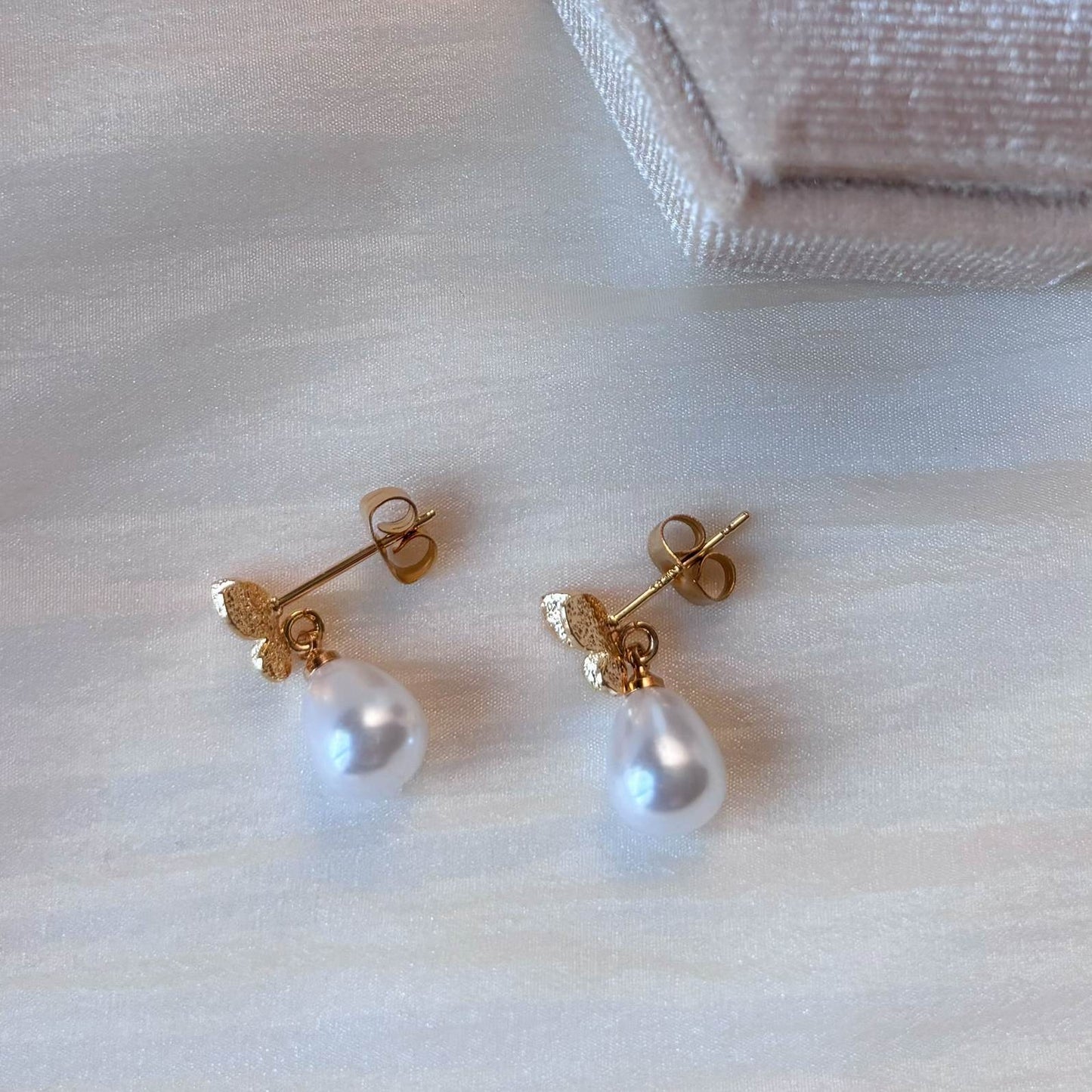 Découvrez les boucles d'oreilles papillon perle de Hana&Alice, pour un mariage plein de charme.