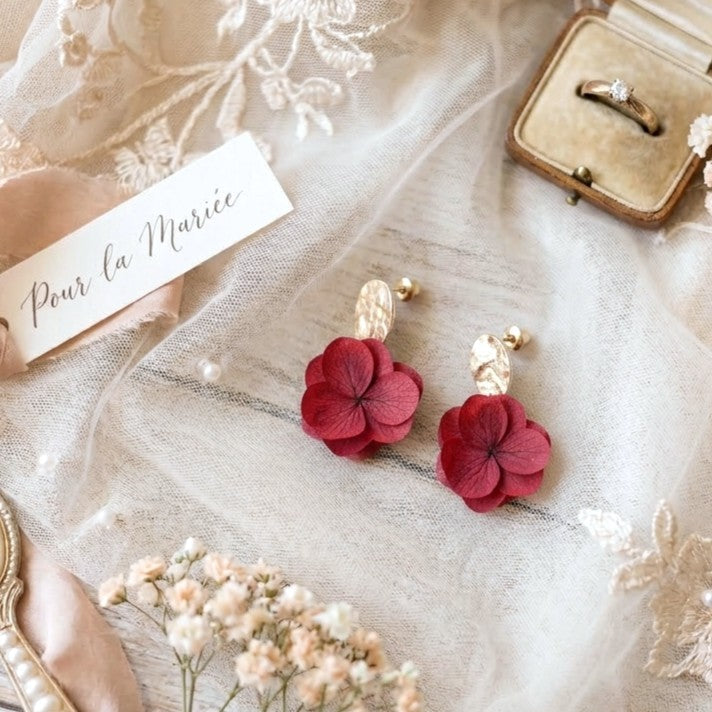 Bijoux mariage rouge avec fleurs stabilisées pour cérémonie estivale ou automnale