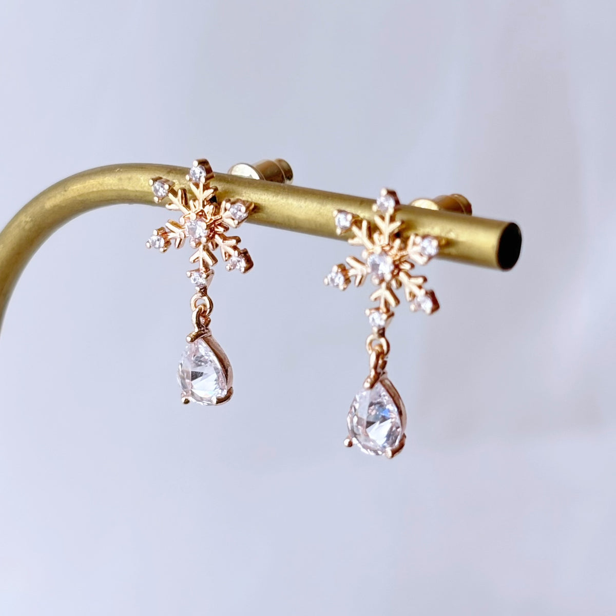 Bijoux d’oreilles dorés avec petit flocon de neige scintillant