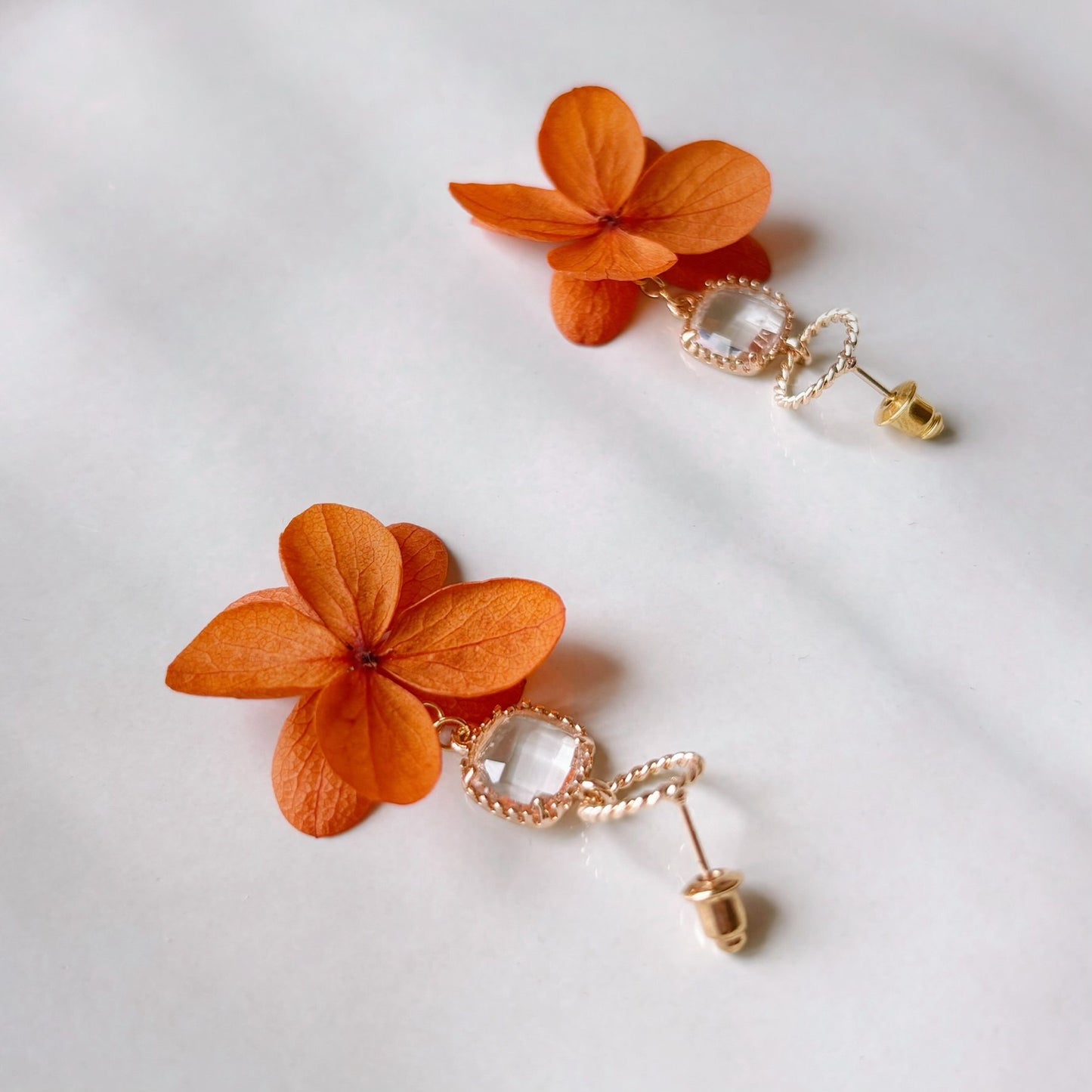 Parure mariage bohème chic avec boucles d’oreilles fleurs terracotta et cristal.