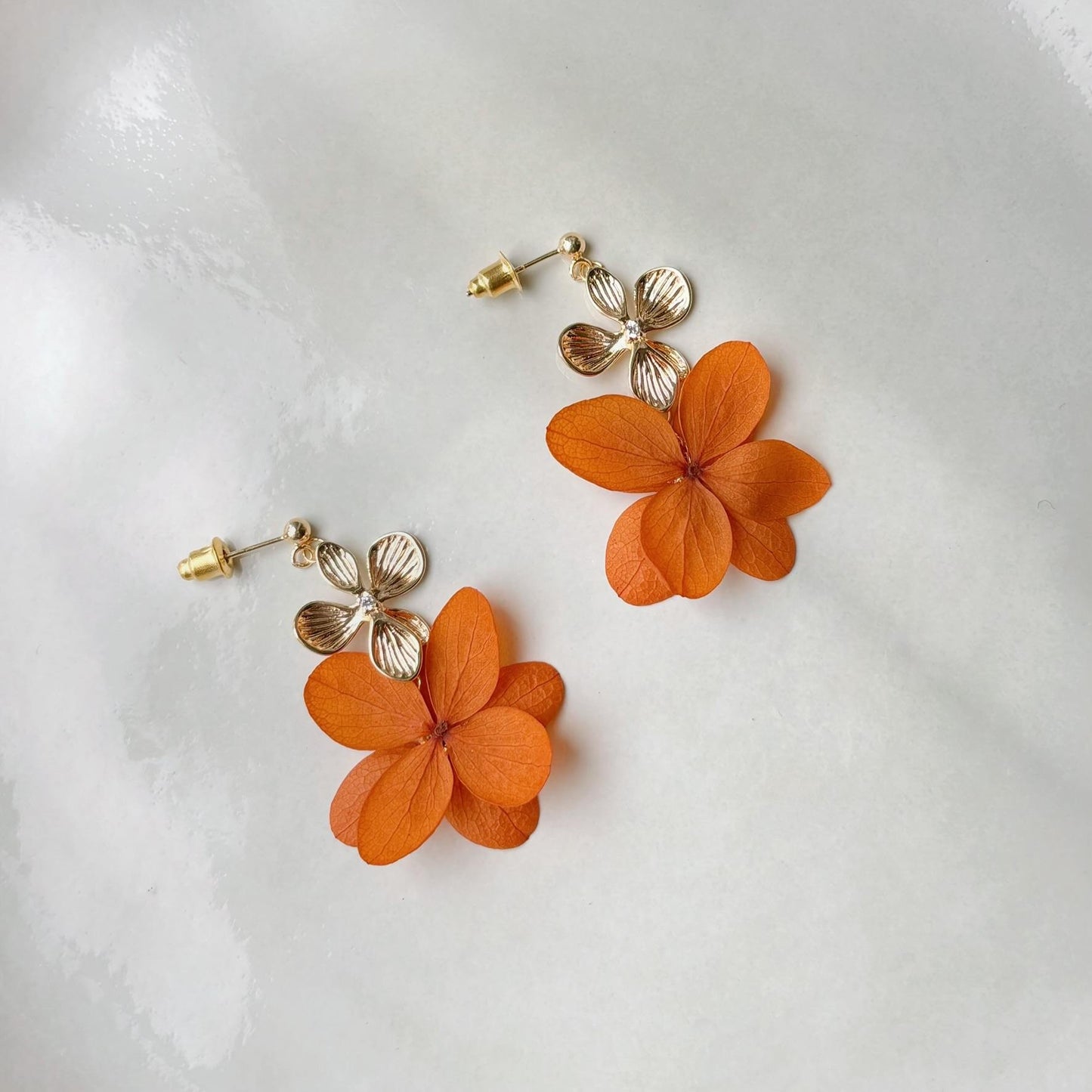 Boucles d’oreilles mariage florales terracotta, parfaites pour compléter une parure mariage.