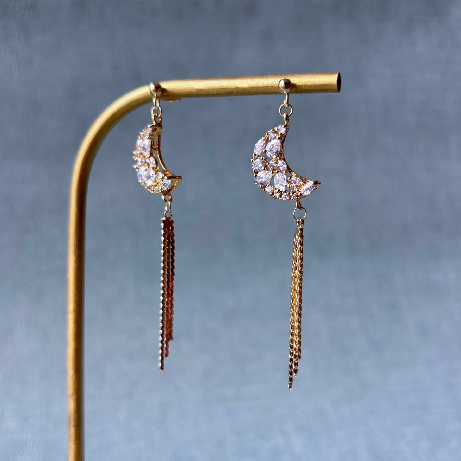 Bijoux poétiques faits main, croissant de lune argenté et chaînes fines lumineuses.