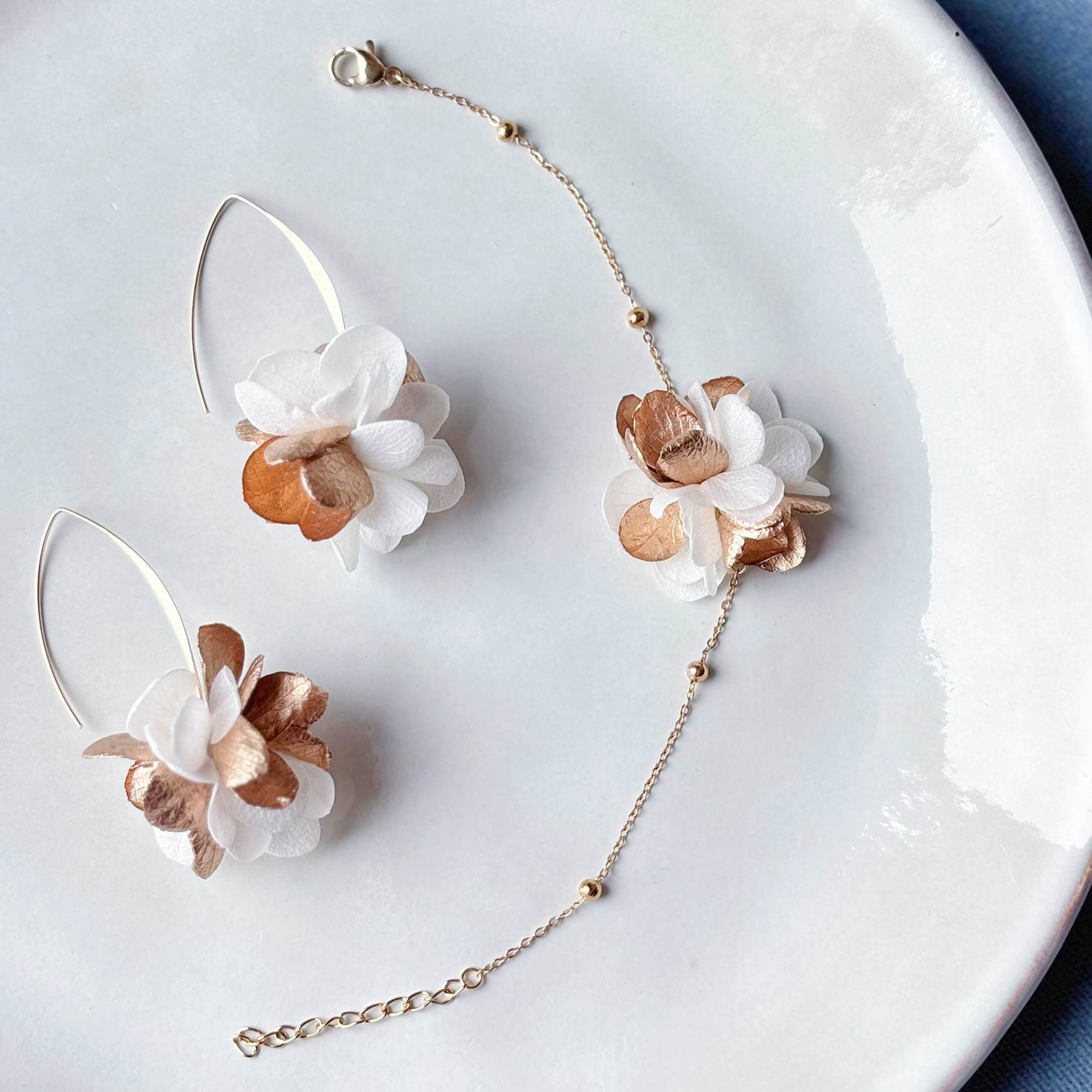 Boucles d'oreilles et bracelet en fleurs stabilisées dorées et blanches pour mariée, style bohème chic et naturel.