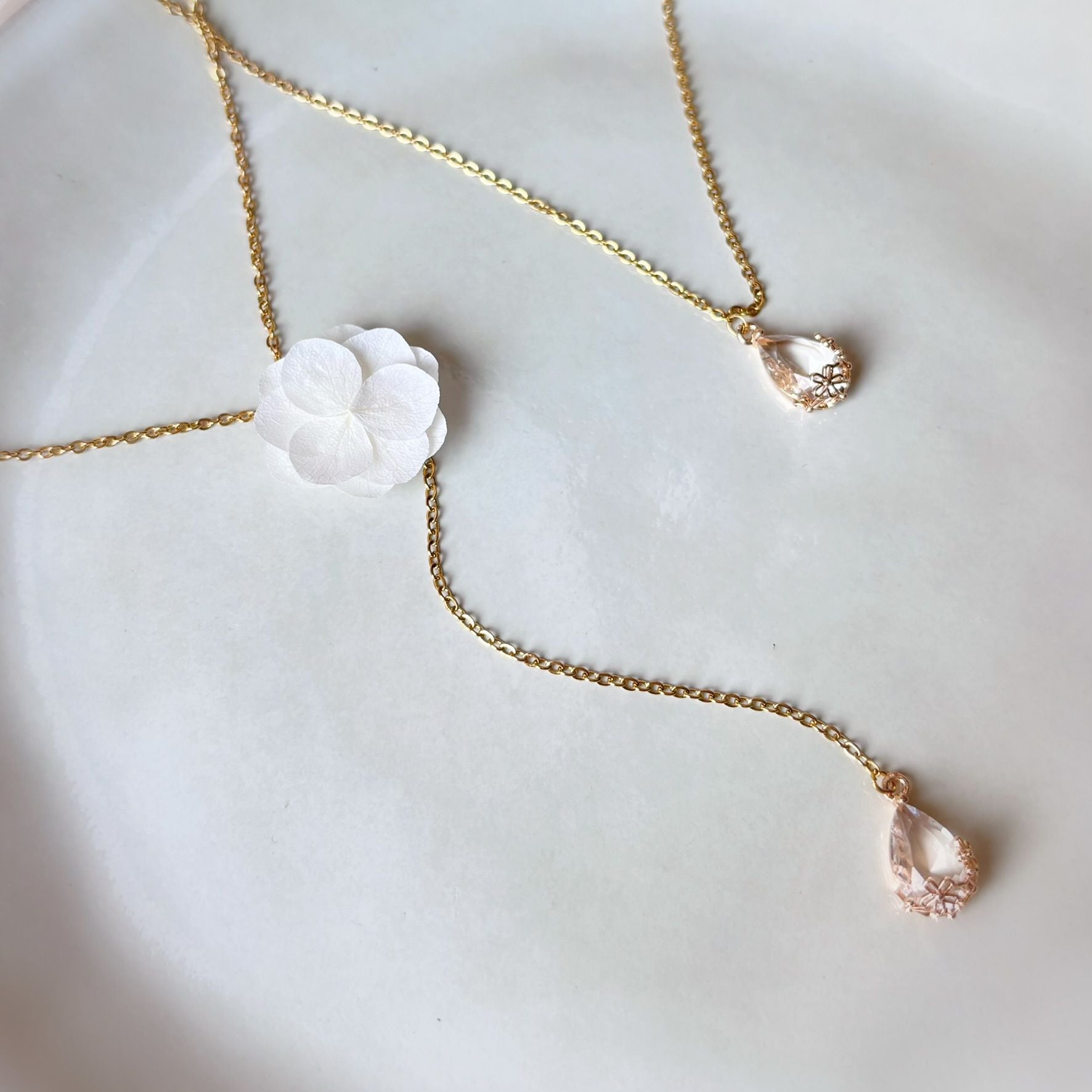 Collier de dos mariage Hana&Alice, décoré de fleurs stabilisées, perles et cristal, bijou mariage raffiné.